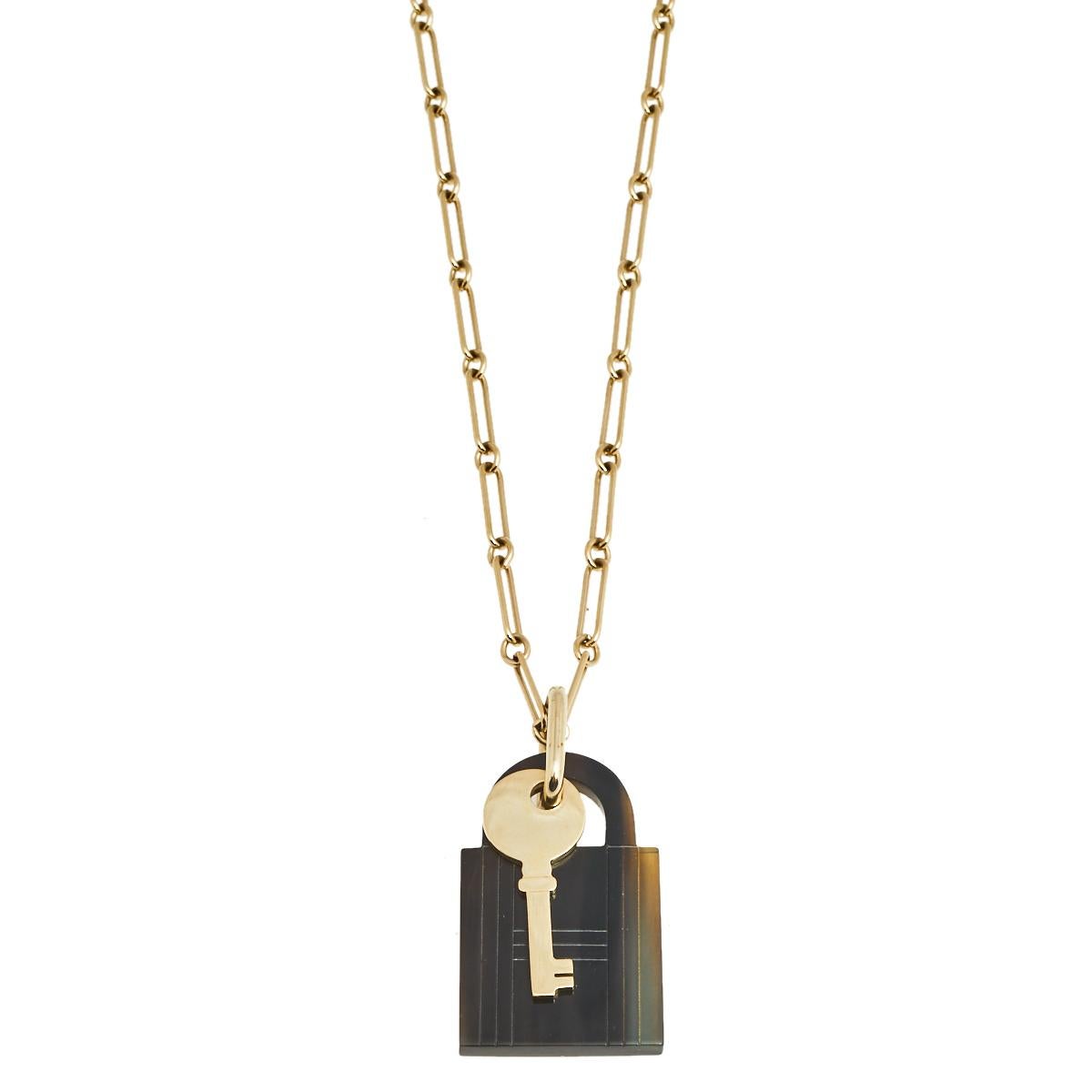 The link necklace by Hermes will adorn any outfit with a sophisticated charm. Crafted from gold-tone metal, it is equipped with a lock and key pendant along with a lobster claw closure attached to the brand plaque. Its elegant design will match with