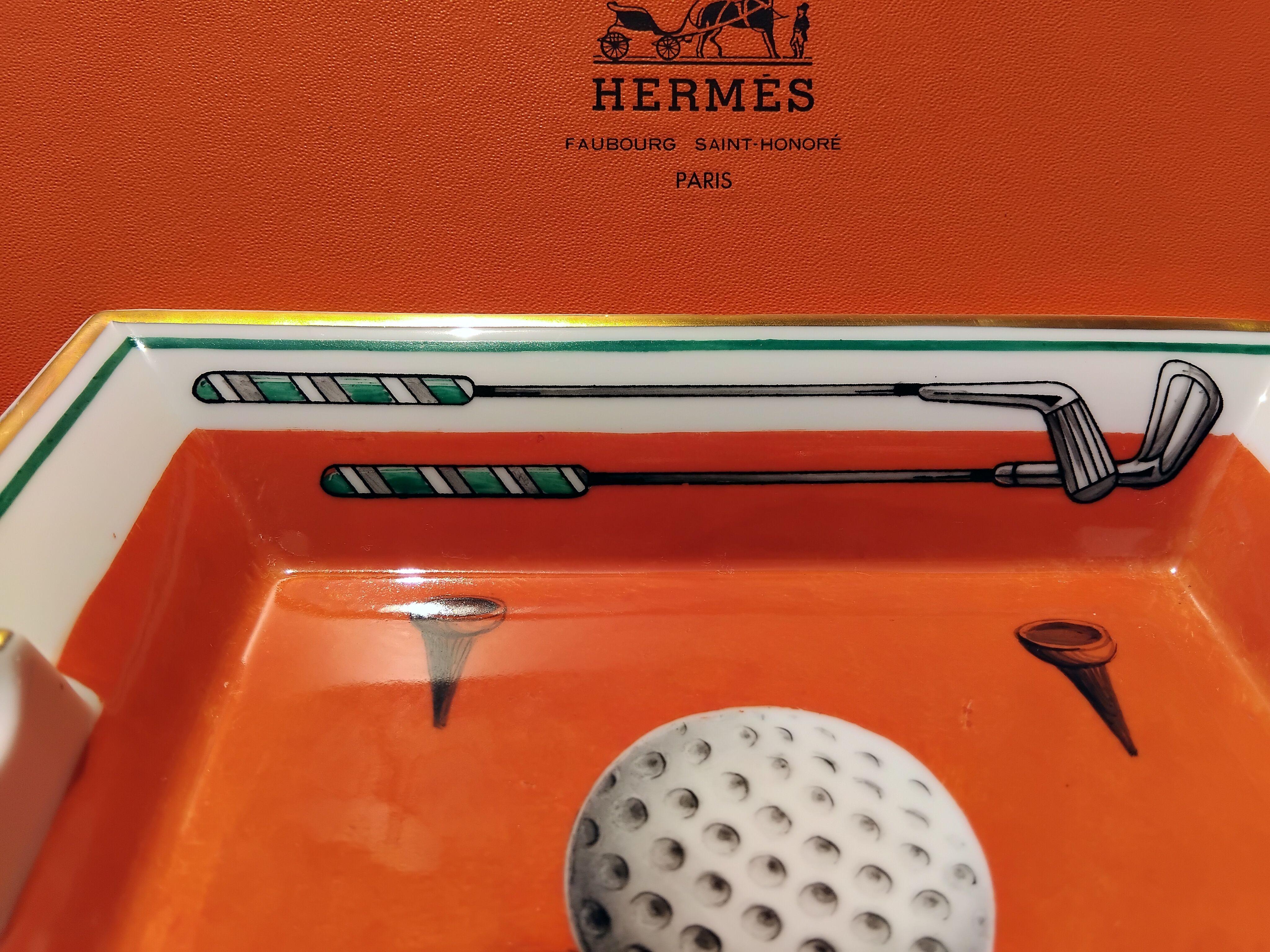 Rare and Beautiful Authentic Hermès Ashtray

Print: Golf Ball, clubs and tees

Made in France

Vintage item

Made of porcelain, edges and notches hand painted with fine yellow gold

Bottom covered with grey suede leather, 