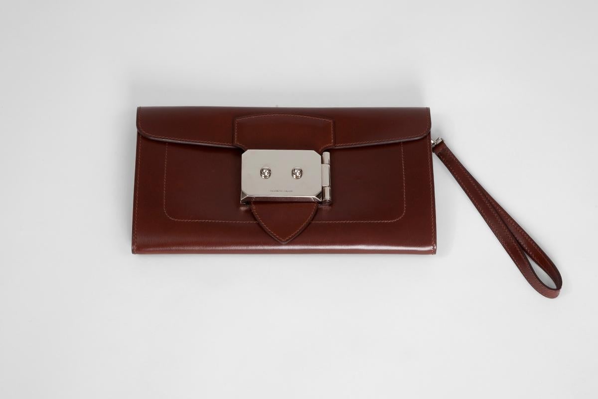 Hermès “Goodlock” clutch in “noisette” box calf leather and palladium hardware. Featuring a fold-over top with push-lock closure, this clutch features a main internal compartment along with one side opened pocket. The interior is fully lined in goat
