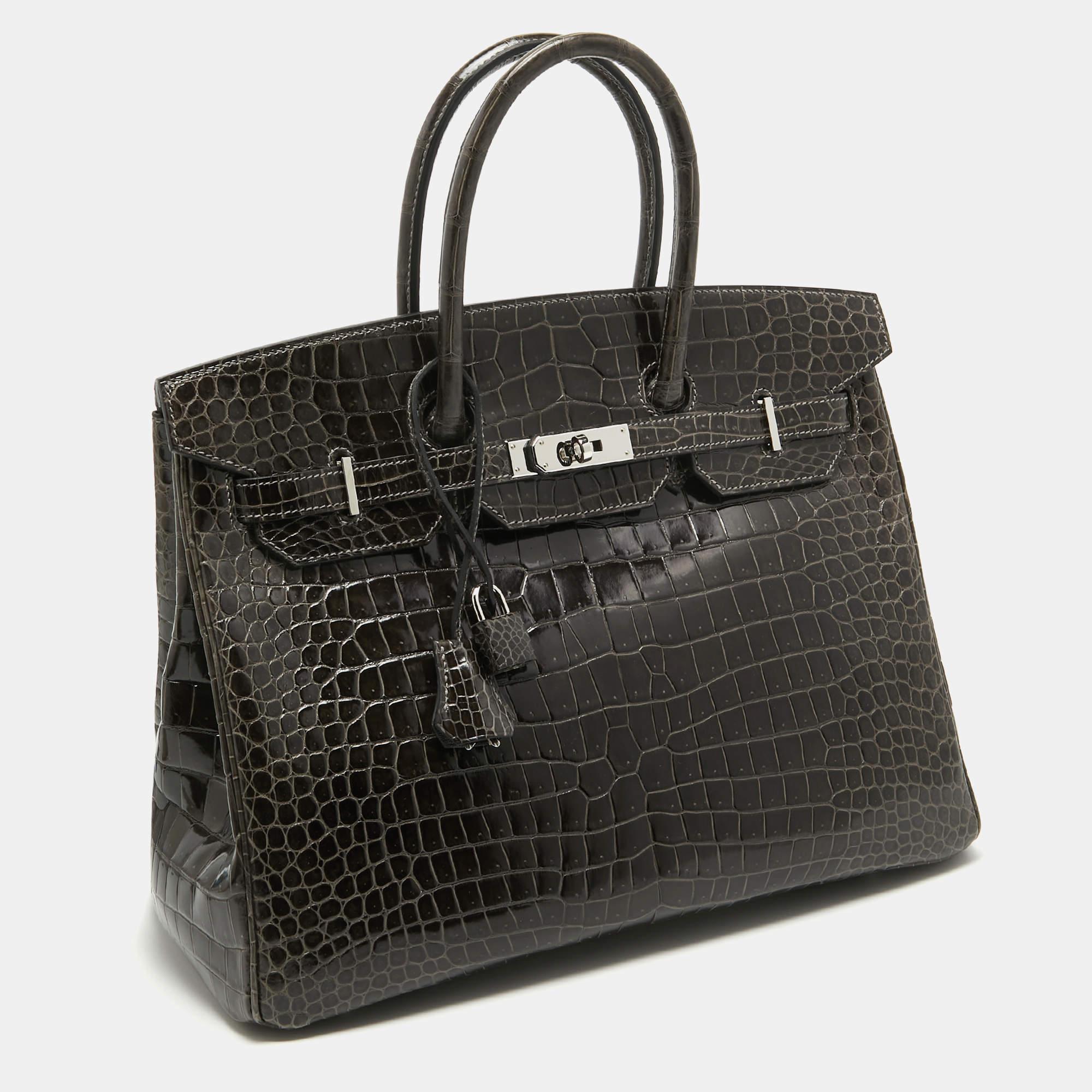 Die Hermès Birkin ist zu Recht eine der begehrtesten Handtaschen der Welt. Die Birkin wird von erfahrenen Kunsthandwerkern in stundenlanger Handarbeit aus hochwertigem Leder hergestellt. Diese Birkin 35 Tasche aus Krokodilporosus wurde mit viel