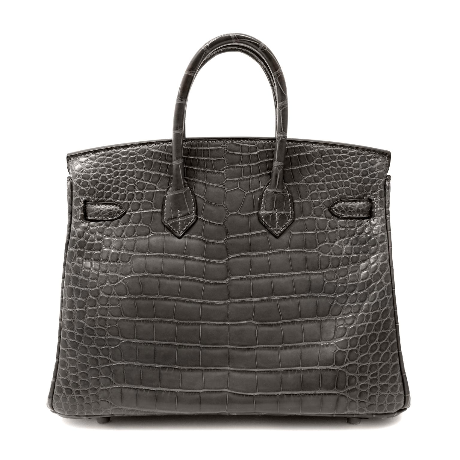 This authentic Hermès 25 cm Graphite Matte Crocodile Birkin is in pristine   unworn condition with the protective plastic intact on the hardware.   Hermès bags are considered the ultimate luxury item the world over.  Hand stitched by skilled