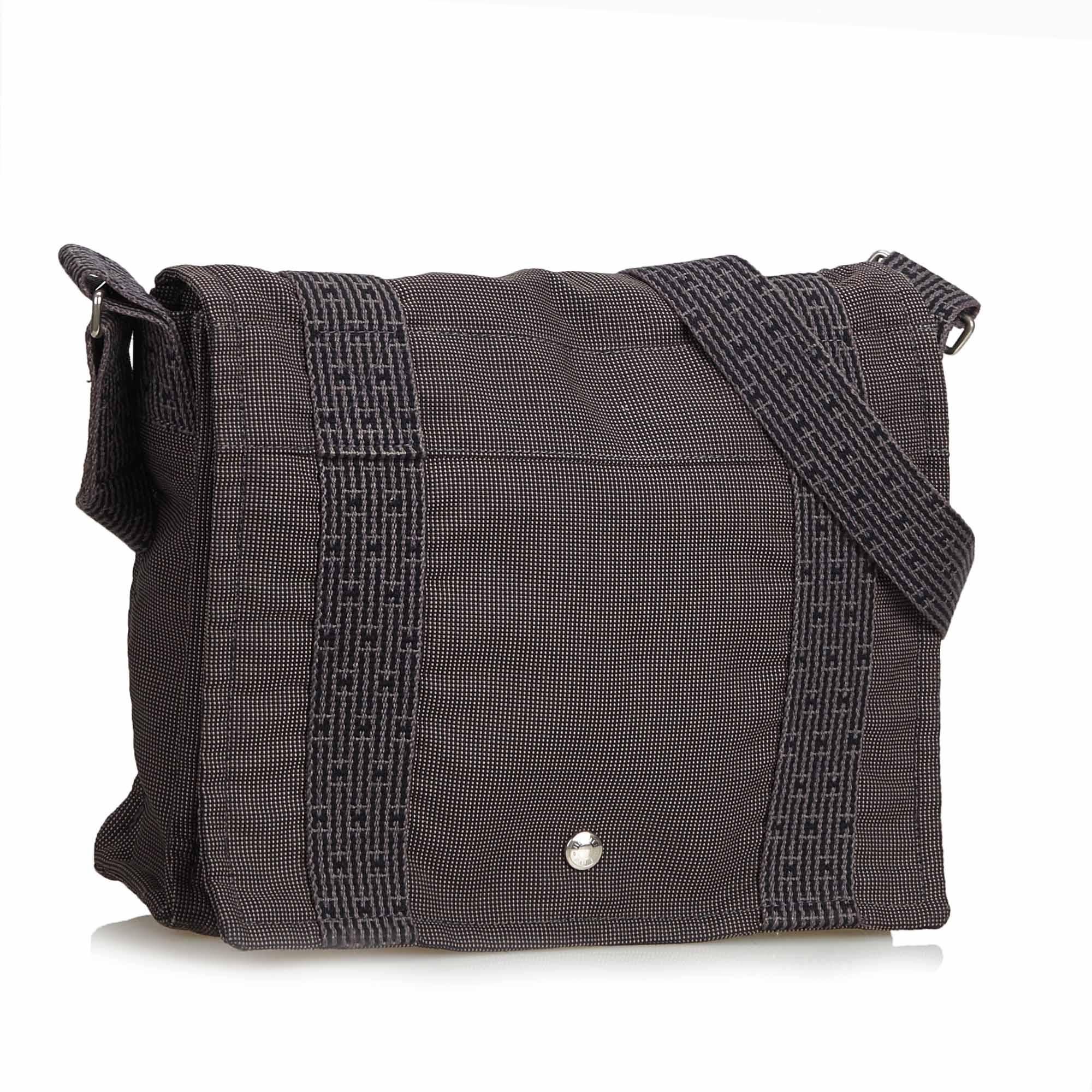 This shoulder bag features a canvas body, flat strap, front flap with button closure and interior zip pocket. It carries as AB condition rating.

Inclusions: 
This item does not come with inclusions.

Dimensions:
Length: 22.00 cm
Width: 30.00