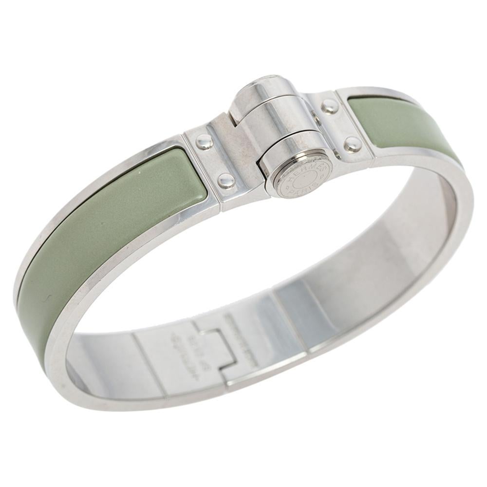 Hermes Charniere Uni bracelet is designed from a palladium-plated body and features a slender silhouette. It is coated with green enamel and is complete with a push-clasp closure. You can easily dress up or down with this simple accessory. Styled