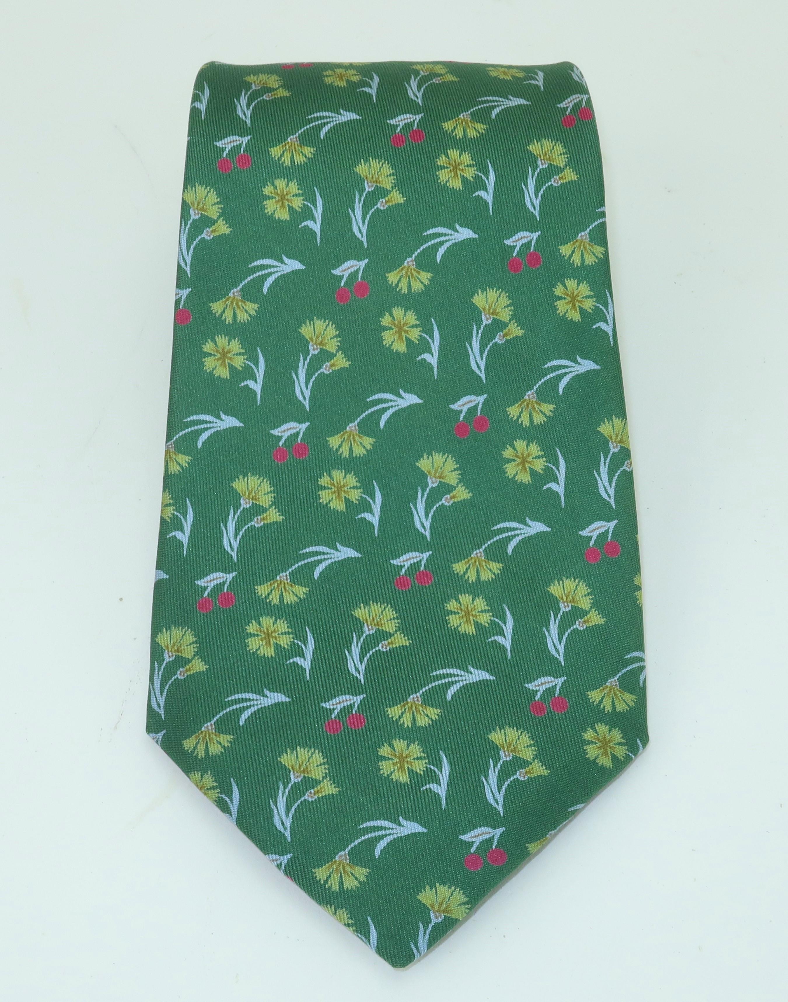 Vintage Hermes silk men’s necktie in a light hearted print combining flowers and stemmed cherries in shades of green, pale blue and cherry red.  It is beautifully made with the quality one would expect from Hermes.  A charming accessory to lighten