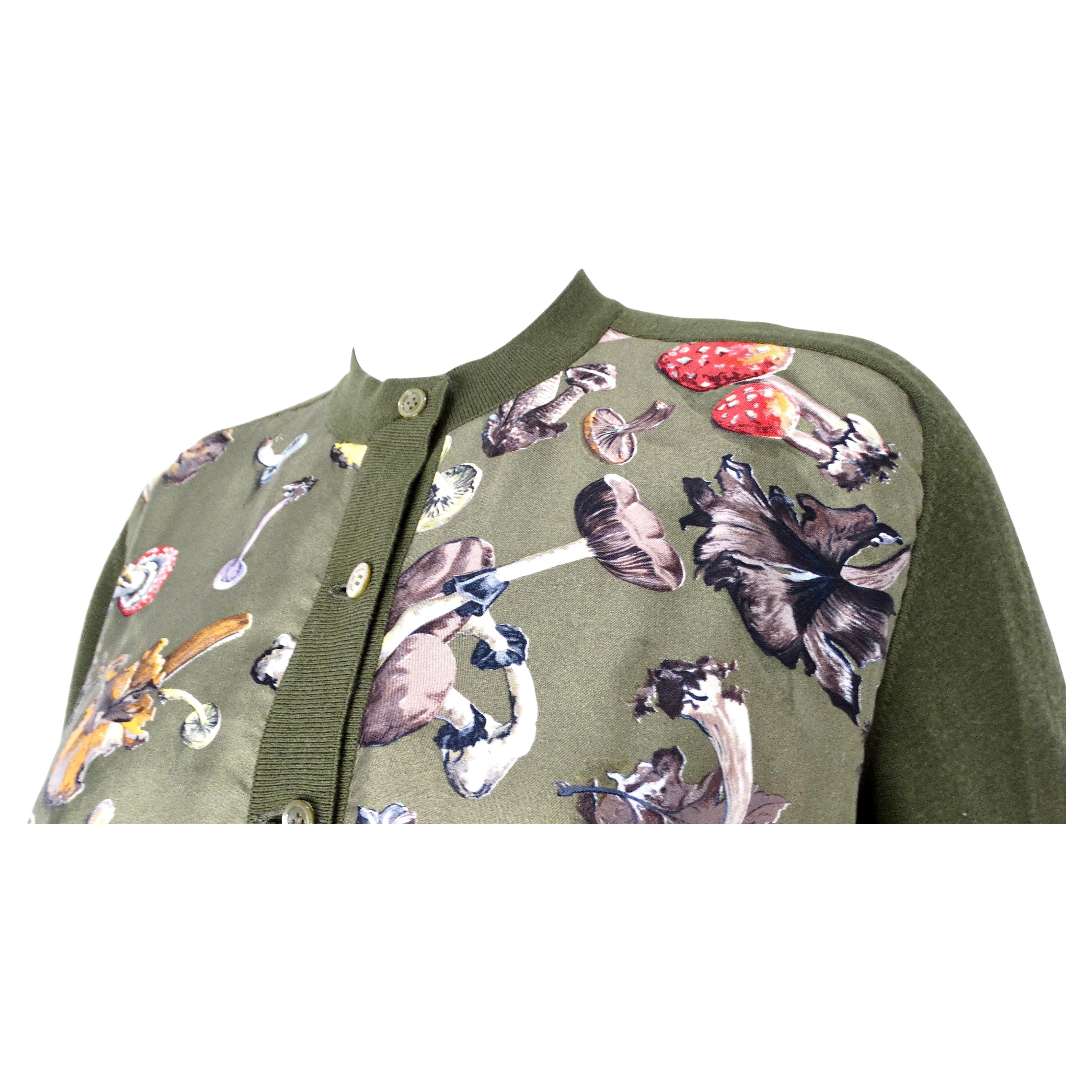 Le cardigan en soie et laine imprimé champignon vert d'Hermès, datant des années 1980, est un exemple frappant de luxe vintage et de design complexe. Confectionné à partir d'un mélange de soie et de laine, il offre une texture sophistiquée qui allie
