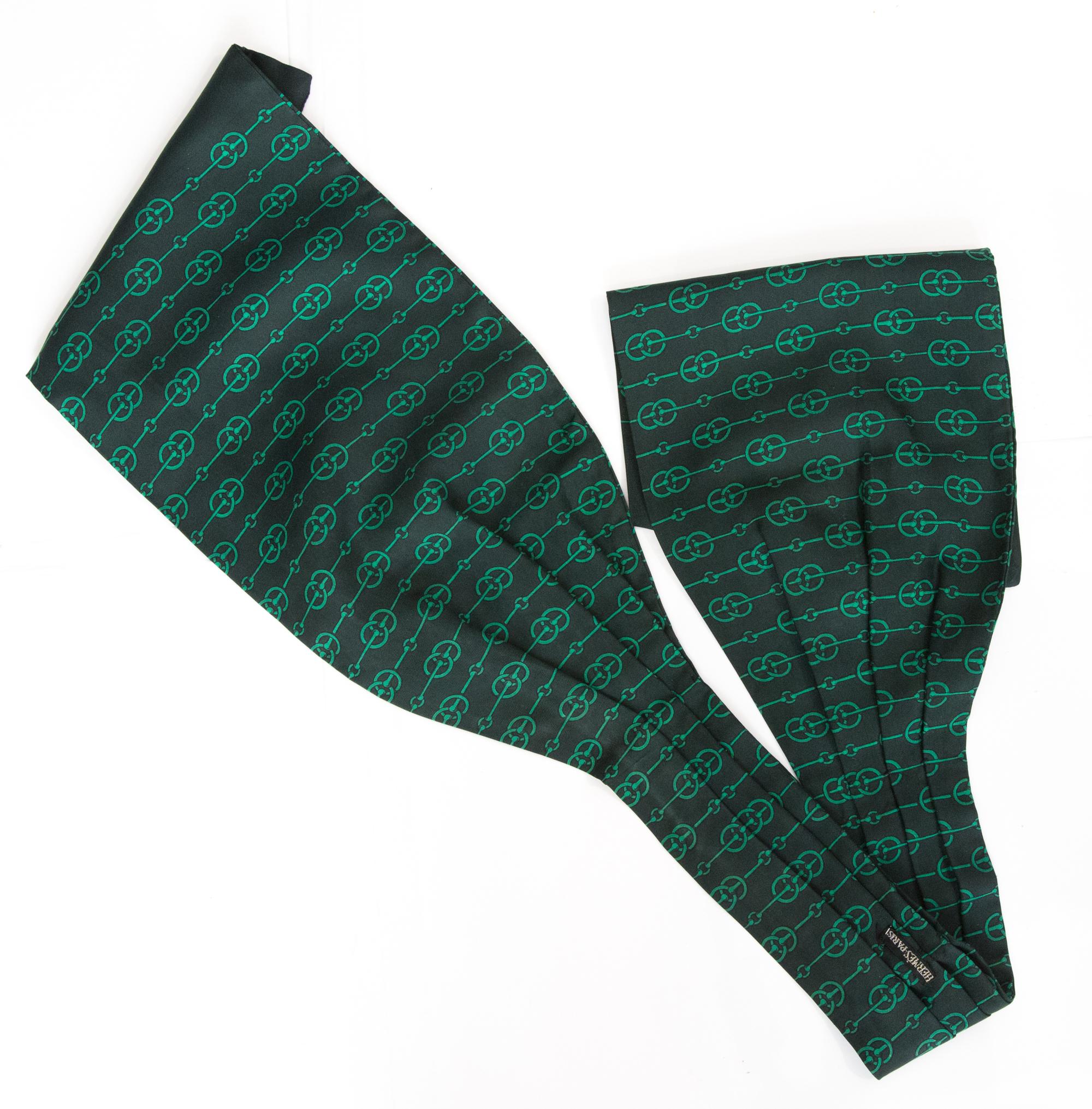 Fular ascot de seda verde Hermès con estampado integral, borde verde y pliegue central. 
Alrededor de 1990 100%seda
En buen estado vintage. Fabricado en Francia.
110 cm X 17 cm
Le garantizamos que recibirá  artículo icónico como se describe y se