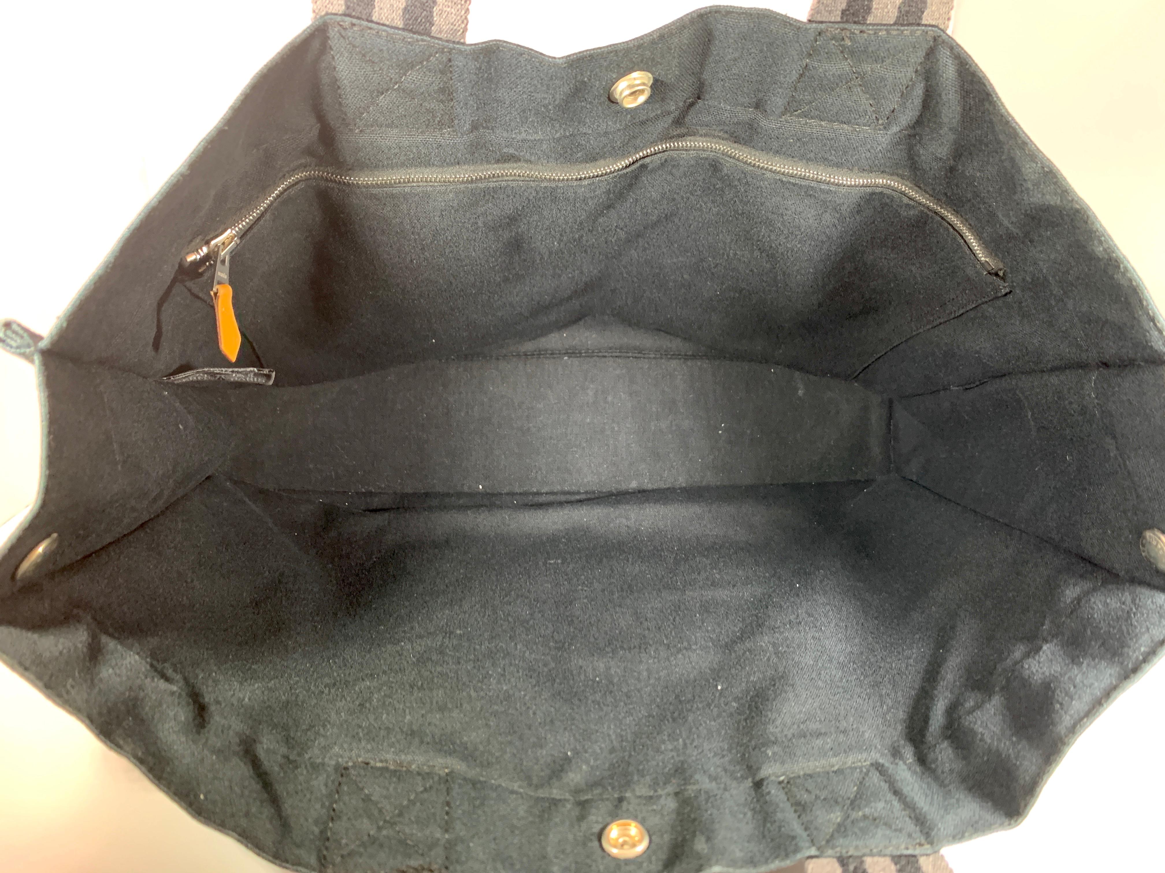 Hermes tote bag fool toe MM black/Grey canvas HERMES   unisex black bag for man and woman 
Zippered pocket inside 
out side has three slip pockets on each side
closure snap buttons on side of the bag , one on each side
Fool toe MM
Machine