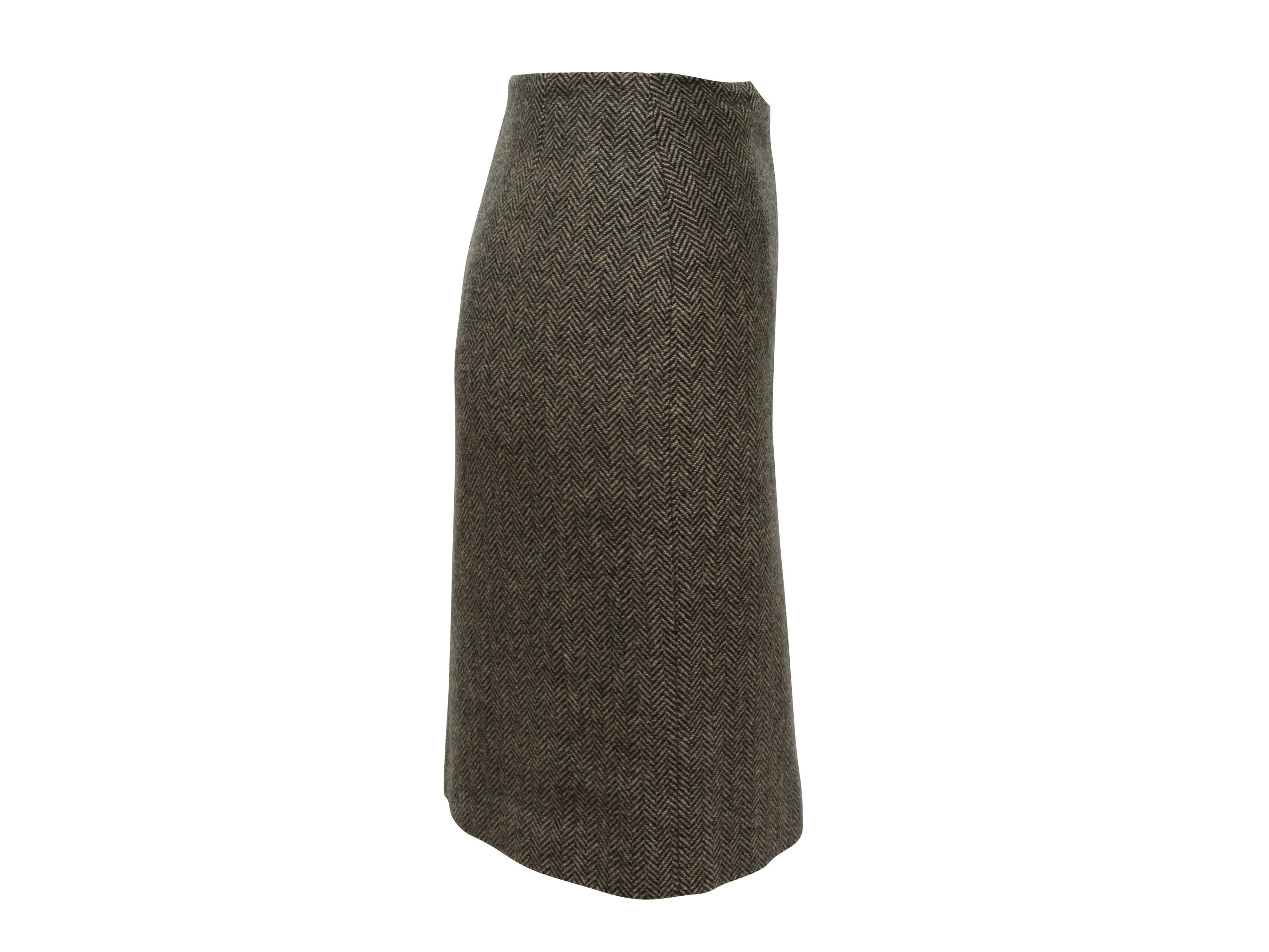 Product details: Vintage grey cashmere herringbone skirt suit and matching shawl by Hermes. Jacket features crew neck, black knit trim and zip closure at front. Skirt features brown leather trim and buckle closure at waist. Shawl features fringe