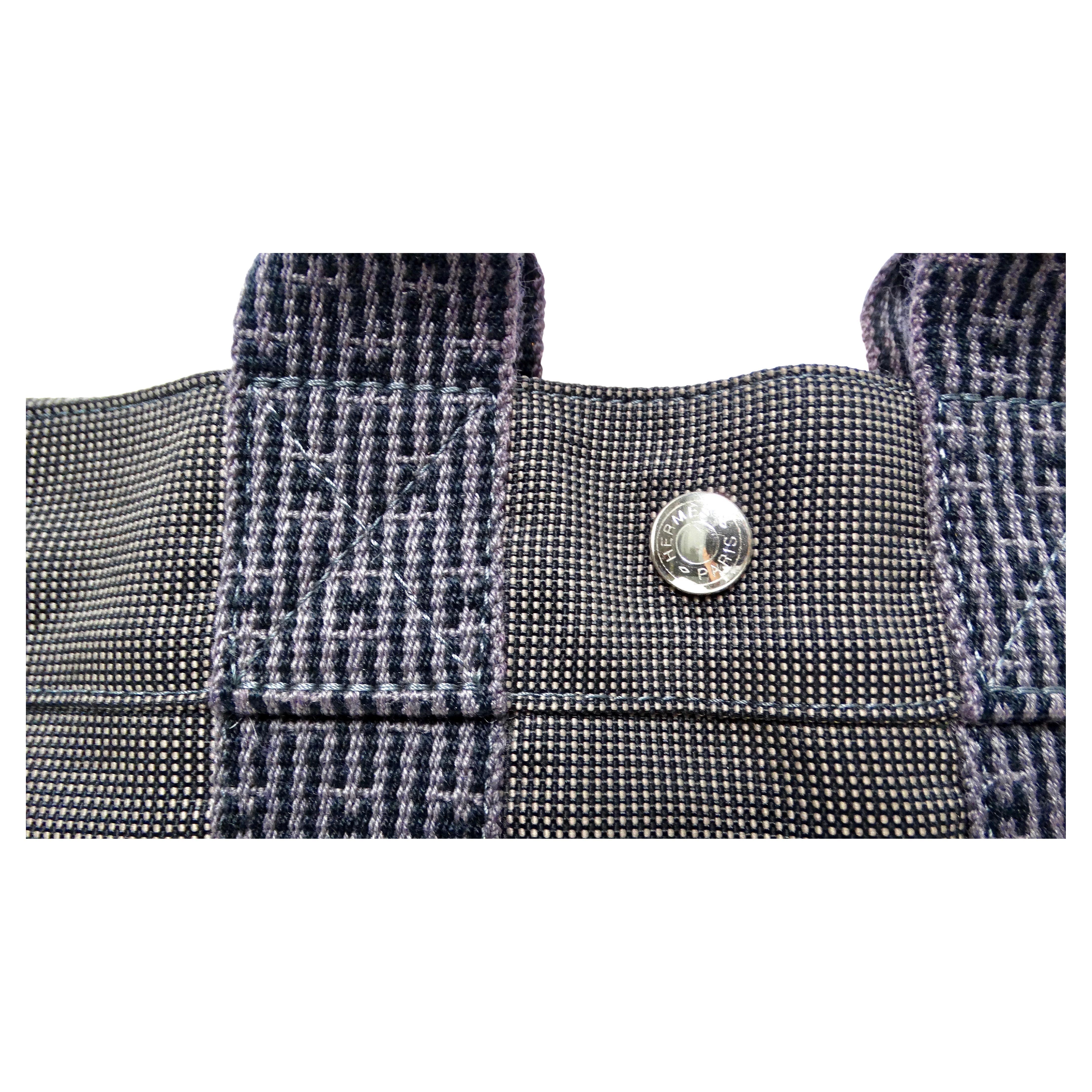 The Hermes Grey Herline Cloth Mini Tote Bag from circa 1990-2000 epitomizes understated luxury and timeless elegance. Crafted from durable yet refined grey fabric, it features subtle Hermes branding, making it a versatile accessory for both casual