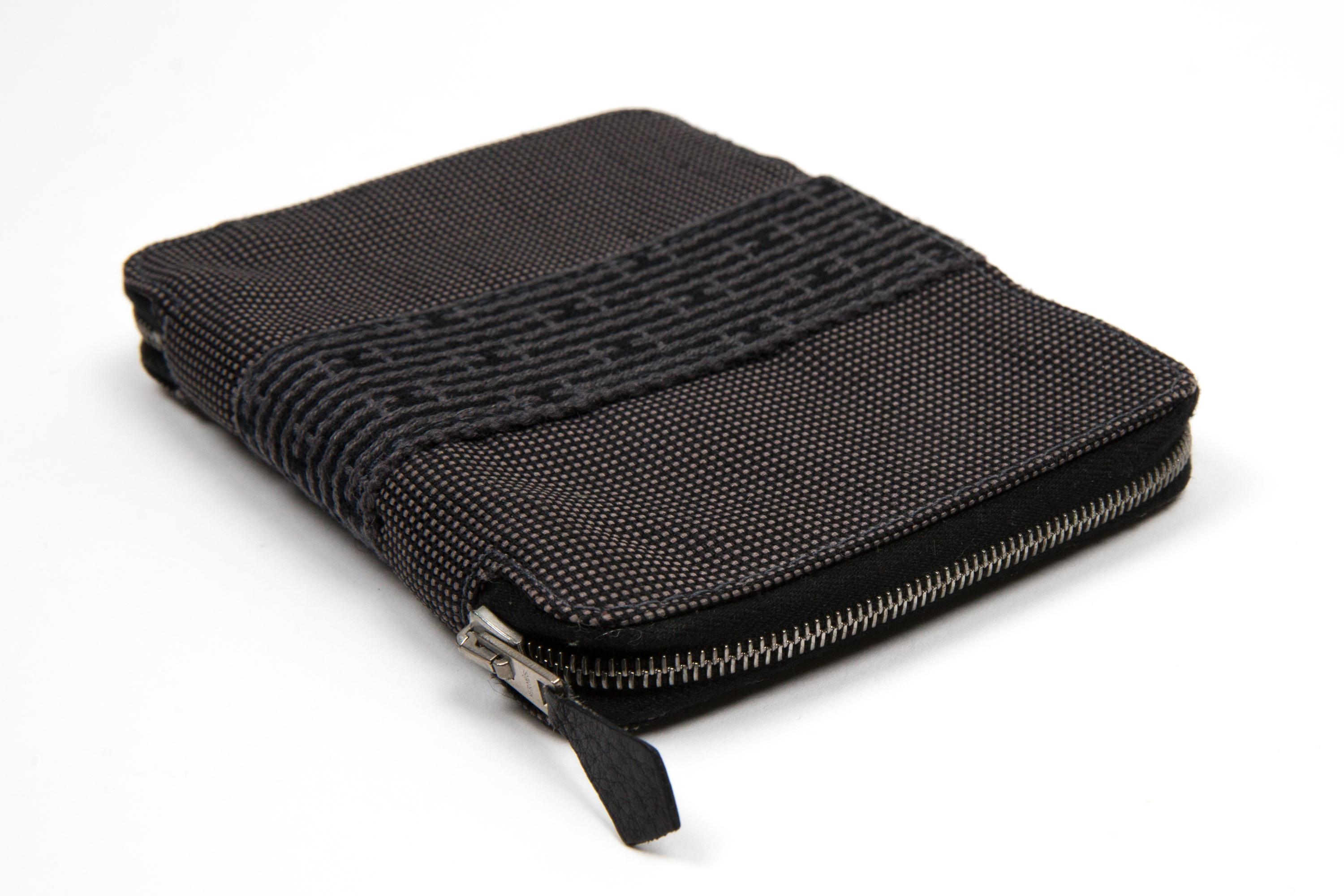 Hermes Grey “Herline” diary cover featuring a silver-tone logo zipper opening, inside black cotton compartments, a cotton brand label. 
Circa: 2000s
In good vintage condition. Made in France.
5.5in. (14cm) X 4in (10.5cm) X 0.8in. (2cm)  
We