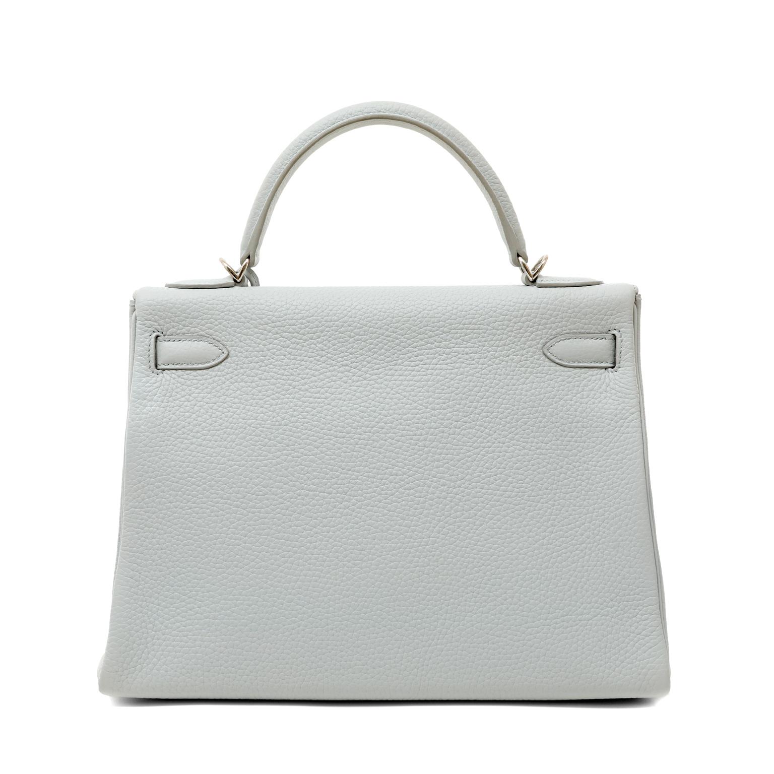 This authentic Hermès Gris Perle Togo 32 cm Kelly is in excellent plus condition.  The demure Kelly is particularly sophisticated in icy grey with Palladium hardware.  
Gris Perle Togo leather is textured and soft to the hand.  Coordinating chevre