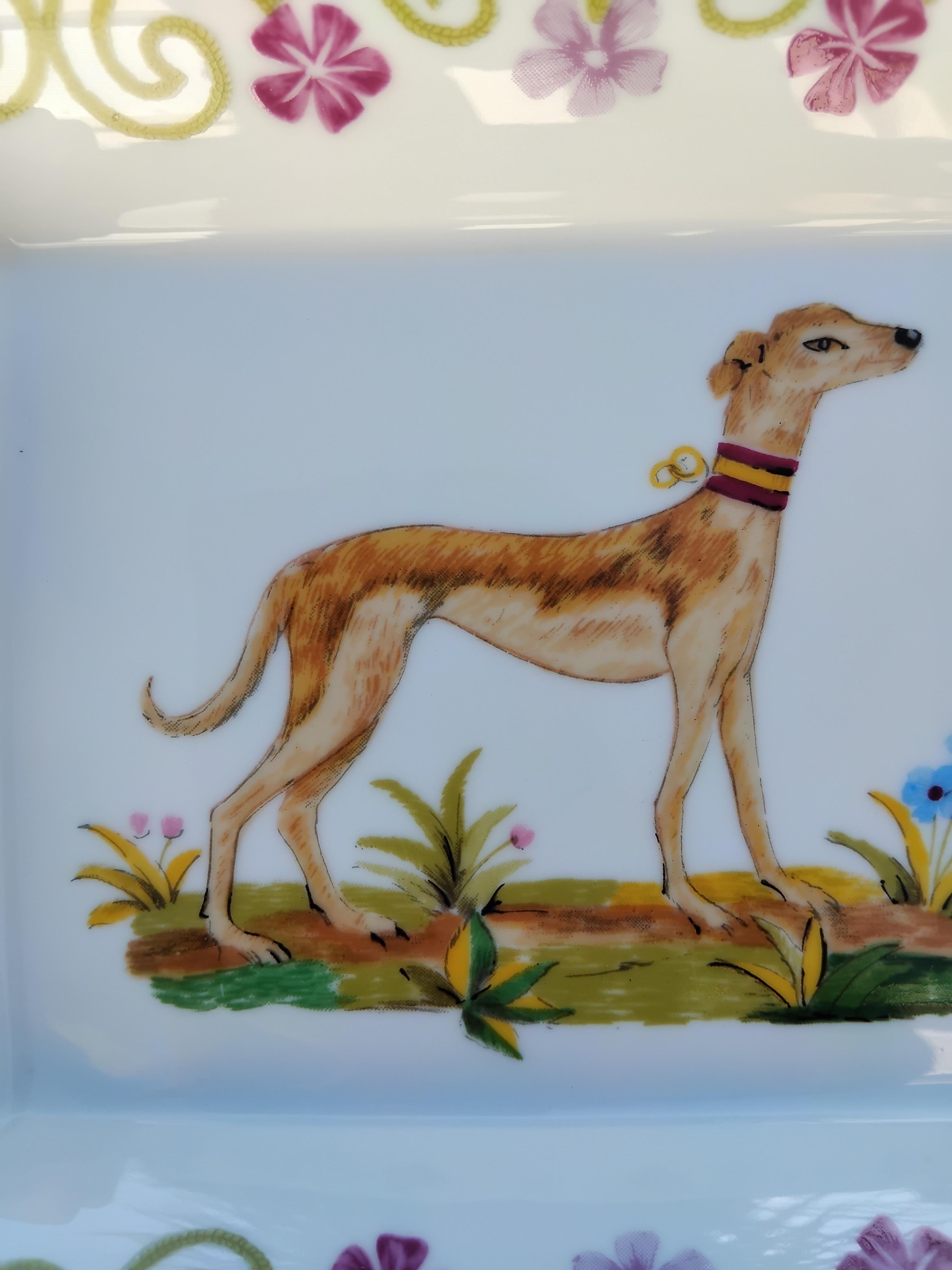 Simpatico e raro posacenere autentico di Hermès

Stampa: Cane levriero o Whippet in un decoro floreale

Prodotto in Francia

Realizzato in porcellana, con bordi e intagli ricoperti di oro giallo fine.

Pelle scamosciata beige sul fondo, 