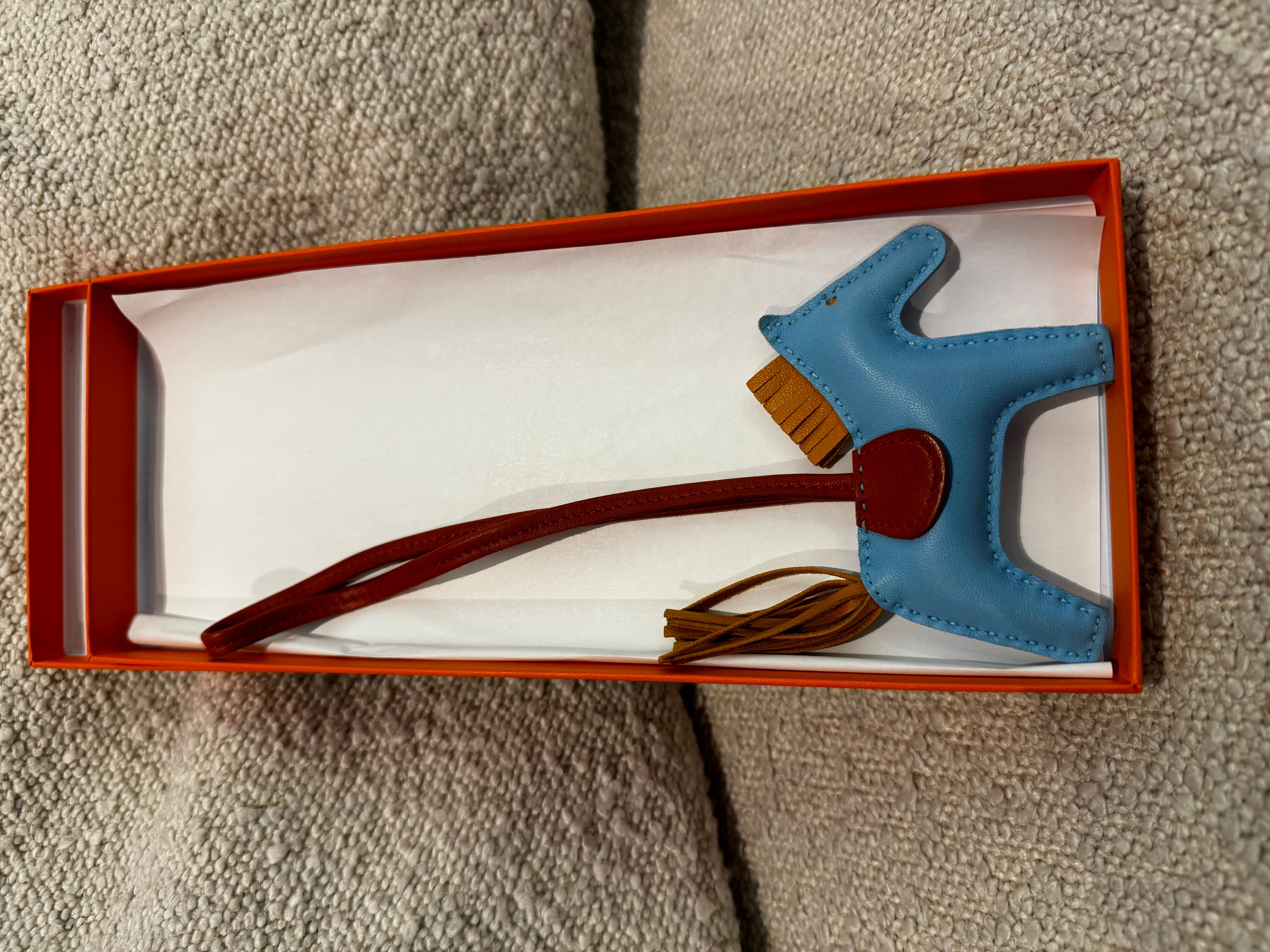 HERMES Milo Lambskin Horsehair Grigri Rodeo Horse Bag Charm PM in Celeste, Naturel Bouton D'Or and Cornaline. So rare, some rodeo are more appreciated than the Hermes Birkin/kelly bags. This lovely bag charm is crafted of stuffed blue lambskin