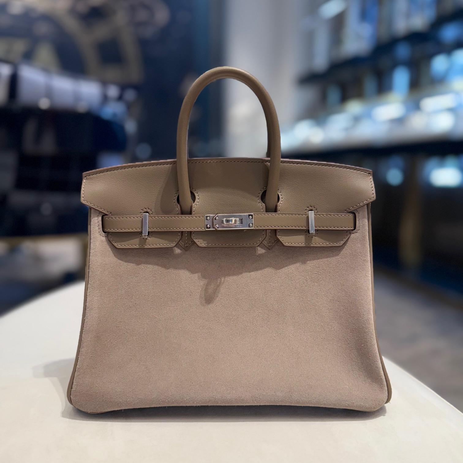 Jewels Aficionado offers the Hermès Gris Caillou & Etoupe Birkin 25, a sophisticated blend of texture and neutral tones. Crafted from Grizzly suede and Swift leather, its soft gray hue contrasts beautifully with Etoupe trim for a refined look. The
