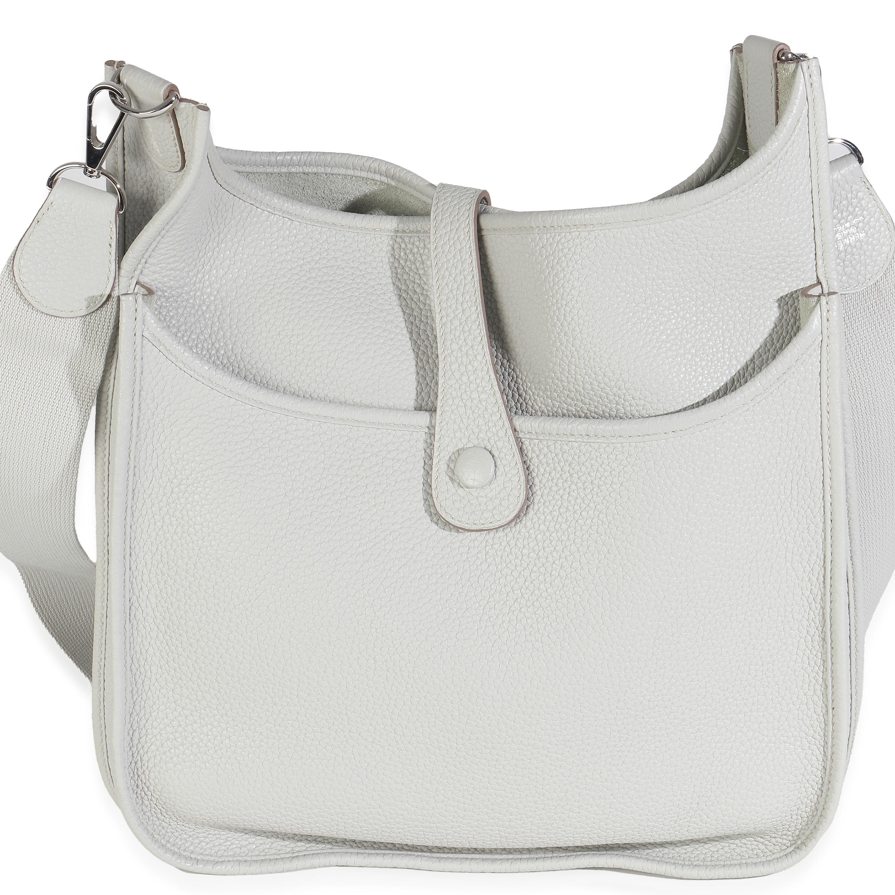 Listing Title: Hermès Gris Perle Clemence Evelyne III 29 PHW
SKU: 148054
Condition: Pre-owned 
Condition Description: Designed in 1978 by Evelyne Bertrand, the Evelyne shoulder bag from Hermès has a distinctive aesthetic thanks to a perforated 'H'