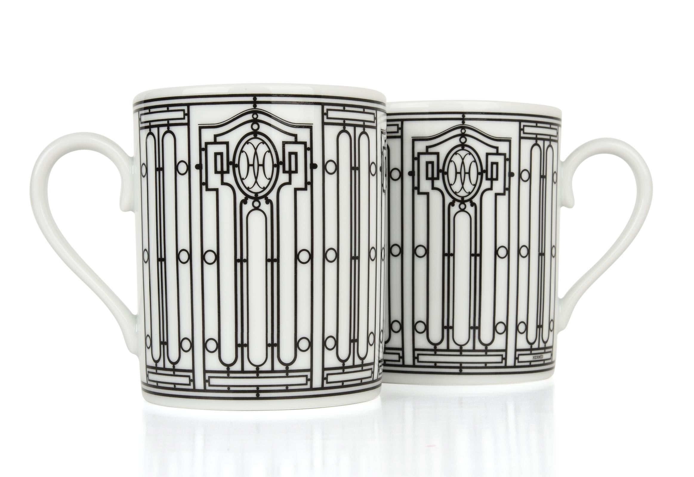 Guaranteed authentic set of two (2) Hermes H Deco mugs featured in white with black.
Features Art Deco wrought-iron friezes.
Each 10 oz mug is porcelain.
All are Deco themed in design.
Each mug comes with signature Hermes box and ribbon.
NEW or