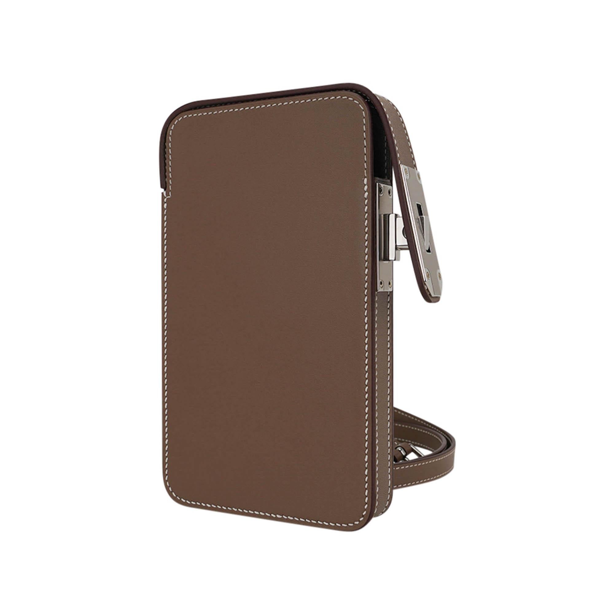Mightychic offers a limited edition Hermes Hac a Box Phone Case featured in Etoupe Tadelakt calf leather.
Rich with Palladium hardware.
This very rare to find versatile case with adjustable strap can be carried on the shoulder or as crossbody.
With