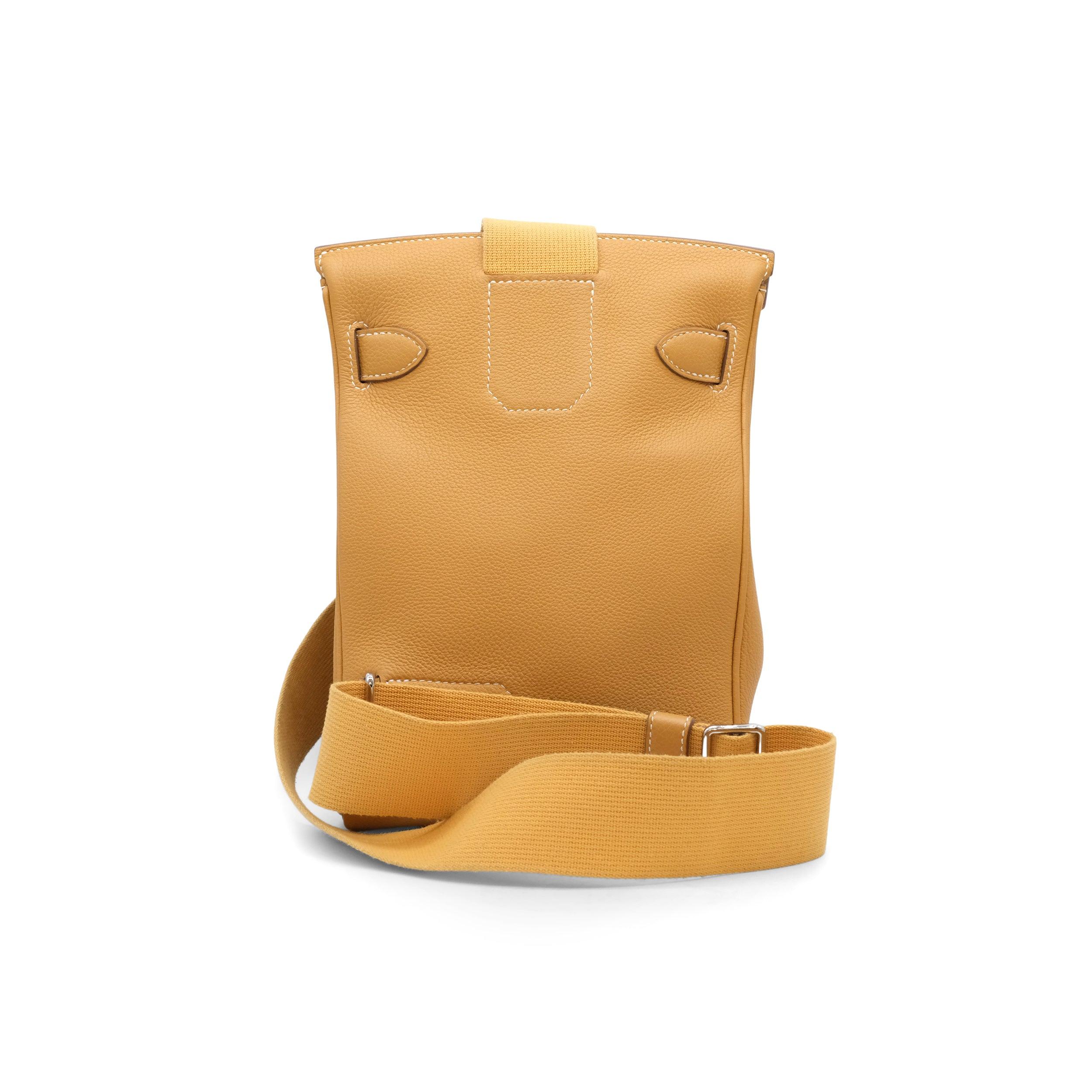 Voici le sac à bandoulière Hac a Dos d'Hermès, confectionné dans un luxueux cuir Natural Sable Togo et rehaussé d'élégantes ferrures en Palladium.
 Ce design unisexe, inspiré de l'emblématique Haut à Courroies, a été lancé en 2022 et offre une