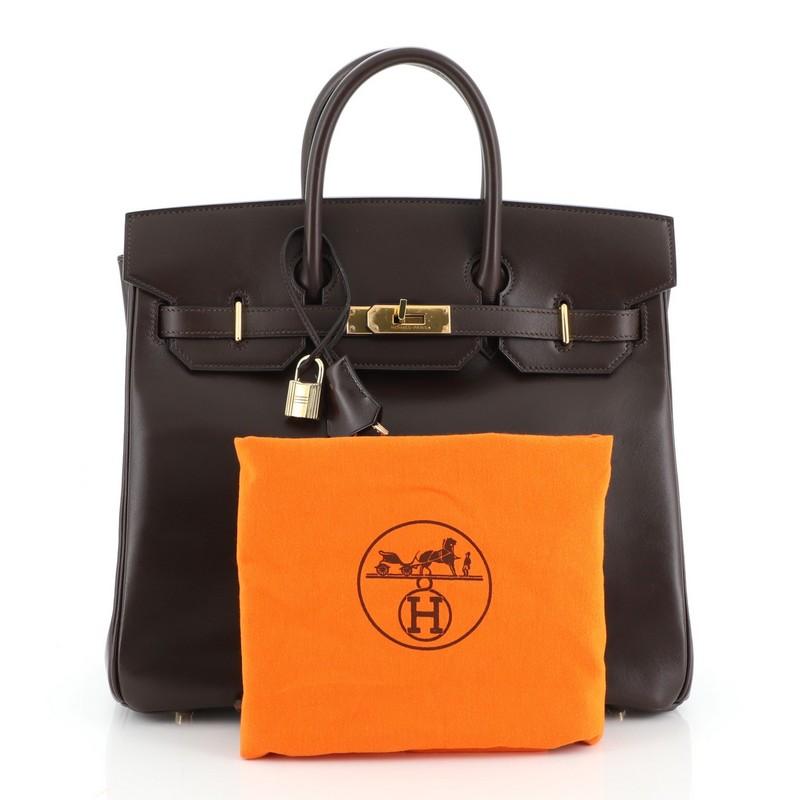 This Hermes HAC Birkin Bag Chocolate Box Calf with Gold Hardware 32, crafted in Chocolate brown Box Calf leather, features dual rolled handles, frontal flap, and gold hardware. Its turn-lock closure opens to a Chocolate brown Chevre leather interior