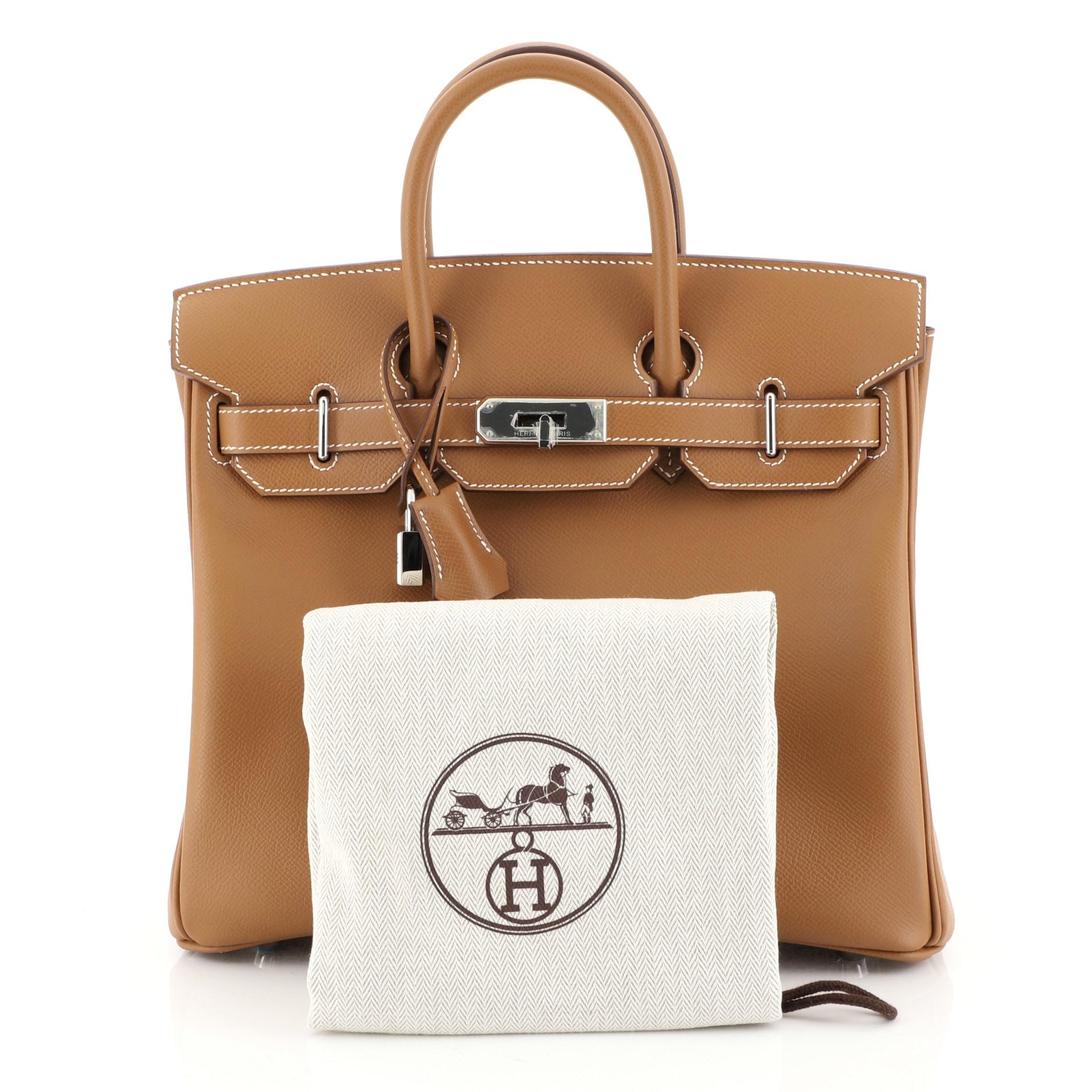 This Hermes HAC Birkin Bag Gold Epsom with Palladium Hardware 28, crafted in Gold brown Epsom leather, features dual rolled handles, front flap, and palladium hardware. Its turn-lock closure opens to a Gold brown Epsom leather interior with zip and