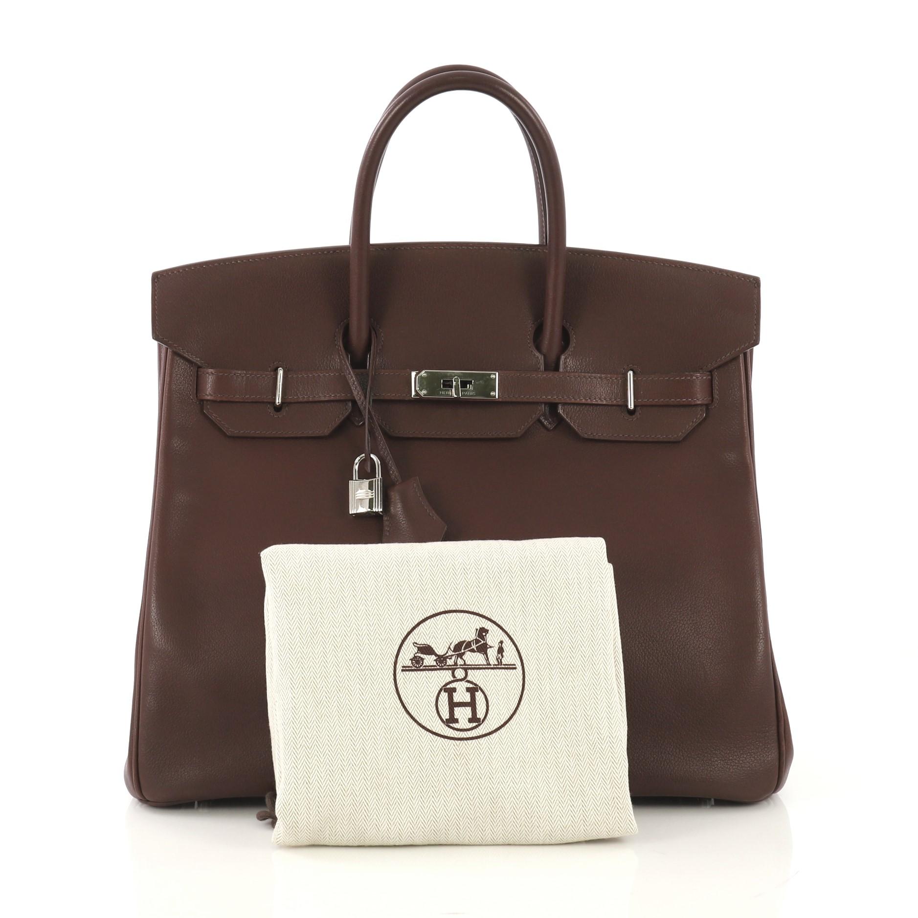 This Hermes HAC Birkin Bag Havane Evergrain with Palladium Hardware 36, crafted in Havane brown Evergrain leather, features dual rolled handles, front flap, and palladium hardware. Its turn-lock closure opens to a Havane brown Chevre leather