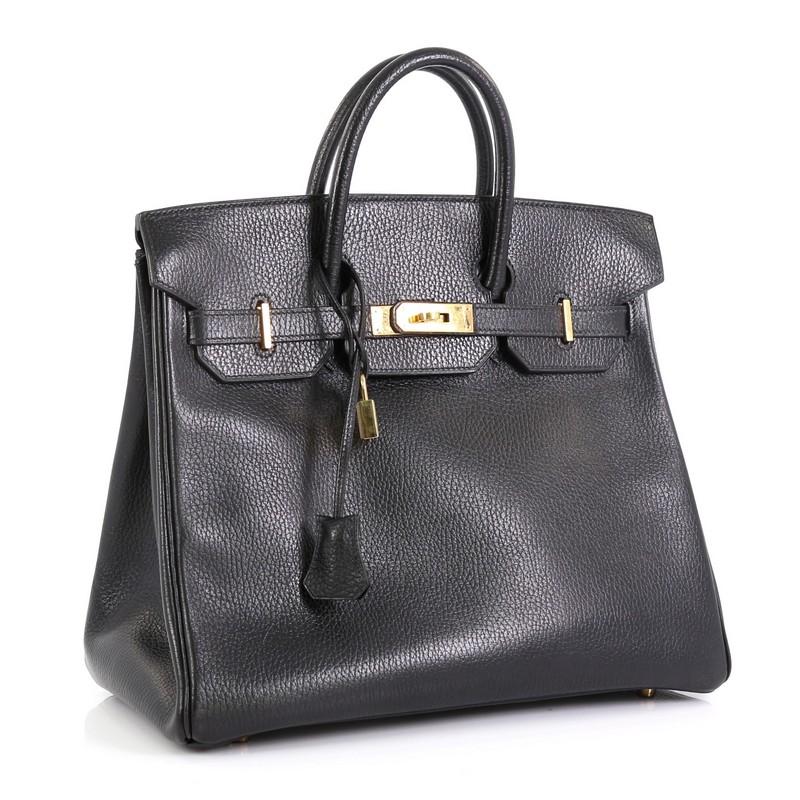 This Hermes HAC Birkin Bag Noir Ardennes with Gold Hardware 32, crafted in Noir black Ardennes leather, features dual rolled handles, frontal flap, and gold hardware. Its turn-lock closure opens to a Noir black Chevre leather interior with zip and