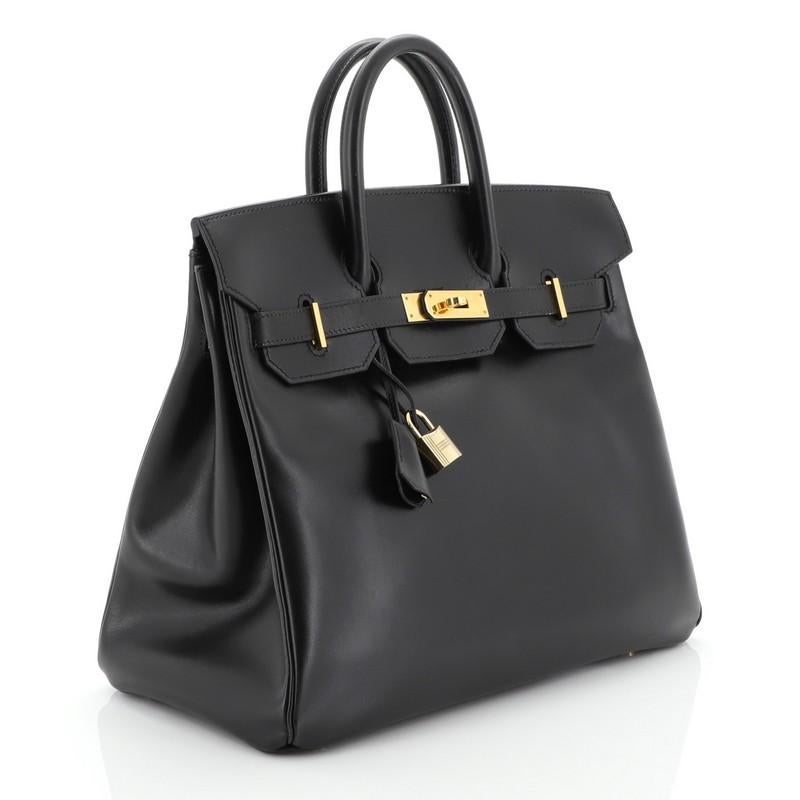 This Hermes HAC Birkin Bag Noir Box Calf with Gold Hardware 32, crafted in Noir black Box Calf leather, features dual rolled top handles, frontal flap, and gold hardware. Its turn-lock closure opens to a Noir black Chevre leather interior with zip