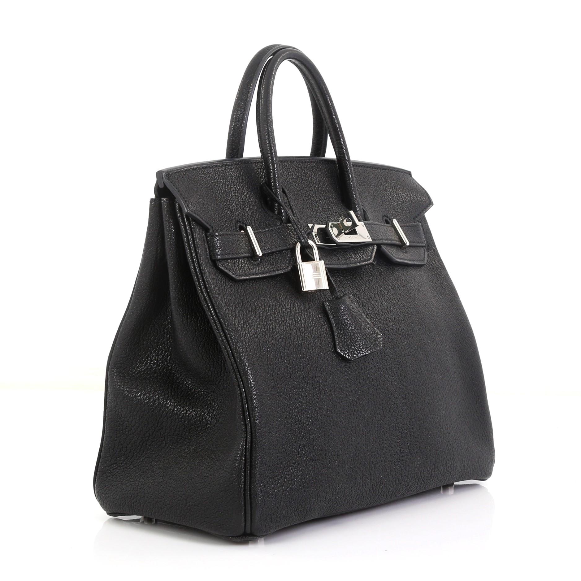 This Hermes HAC Birkin Bag Noir Chevre de Coromandel with Palladium Hardware 28, crafted in Noir black Chevre de Coromandel leather, features dual rolled handles, frontal flap, and palladium hardware. Its turn-lock closure opens to a Noir black