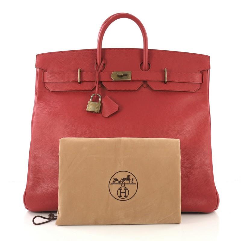 This Hermes HAC Birkin Bag Rouge Vif Ardennes with Gold Hardware 50, crafted in Rouge Vif red Ardennes leather, features dual rolled handles, frontal flap, and gold hardware. Its turn-lock closure opens to a Rouge Vif red Chevre leather interior