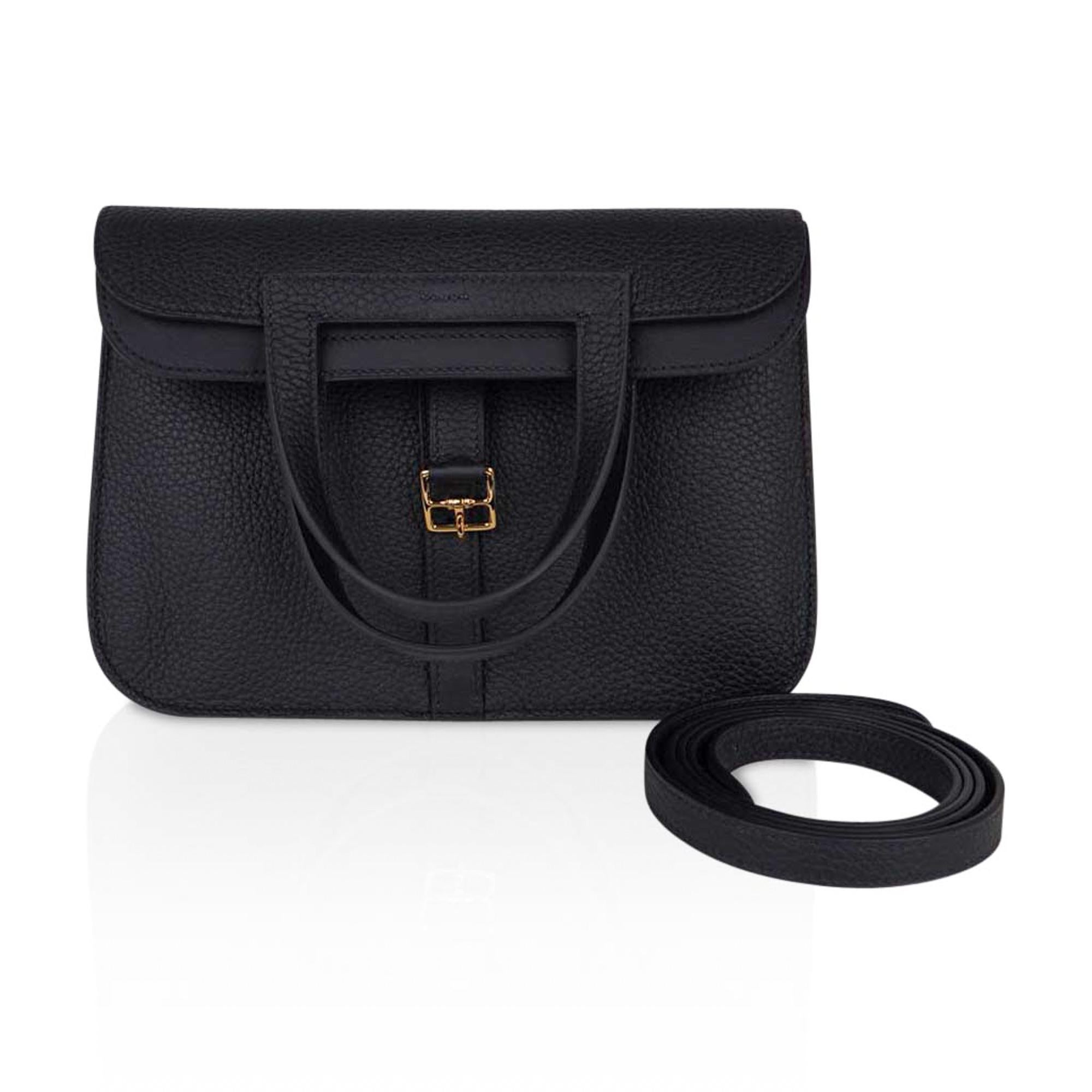 Mightychic offers a guaranteed authentic Hermes Halzan 25 bag featured in Black  with lush with Gold hardware.
Plush Clemence leather.
Versatile three-way bag.
The Hermes Halzan bag is a fresh take on the messenger with the crossbody strap.
Fold