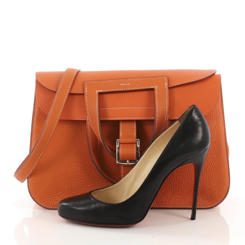 This Hermes Halzan Handbag Clemence 31, crafted from Orange H orange Clemence leather, features dual stirrup-shaped top handles, flat shoulder strap, four exterior flat pockets, and palladium hardware. Its buckle closure opens to an Orange H Swift