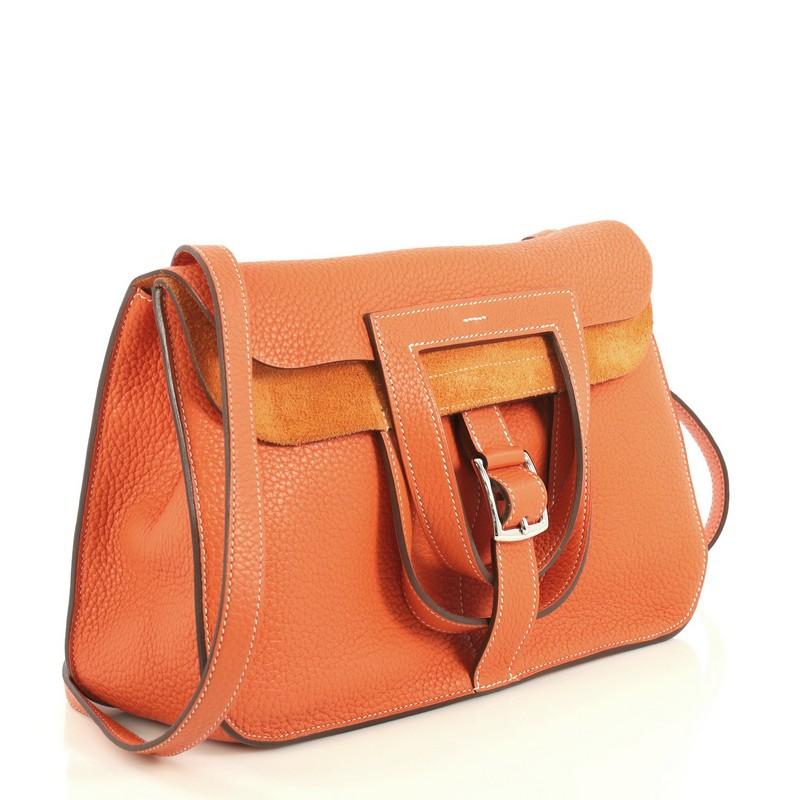 
This Hermes Halzan Handbag Clemence 31, crafted from Orange Poppy orange Clemence leather, features dual stirrup-shaped top handles, flat shoulder strap, four exterior flat pockets, and palladium hardware. Its buckle closure opens to an Orange