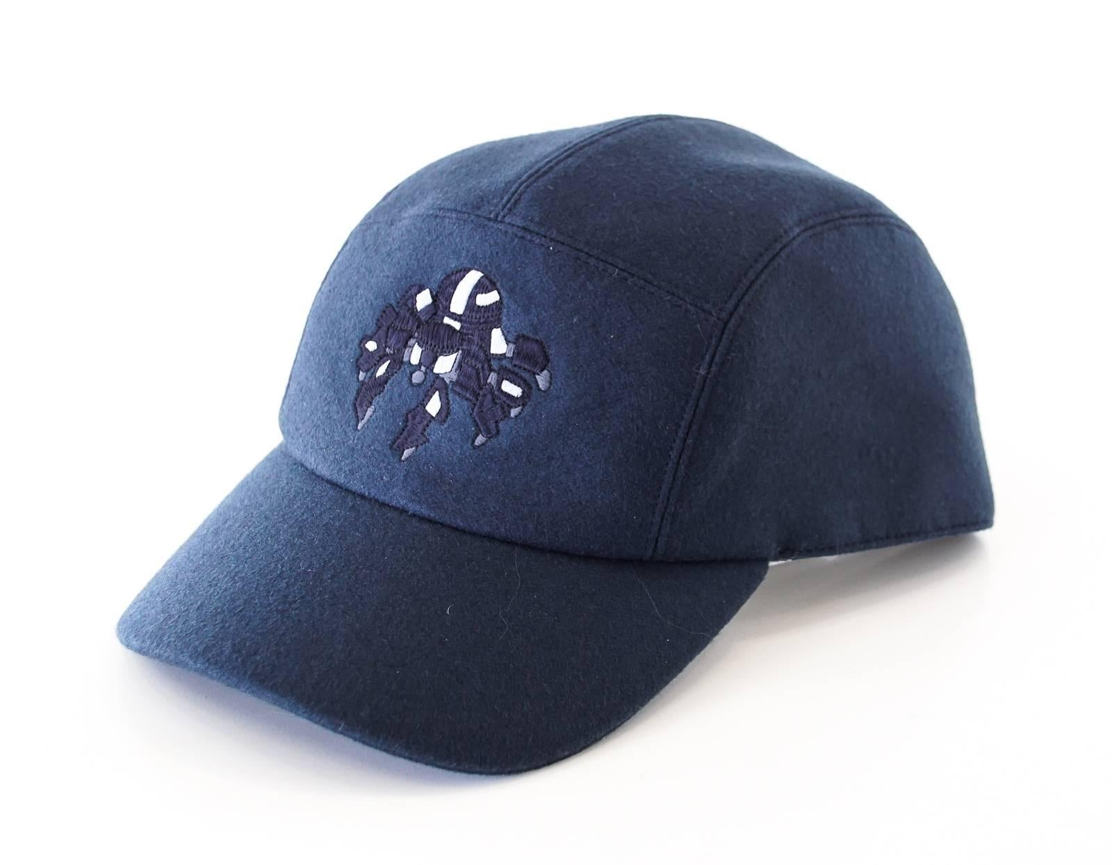 Mightychic offers an Hermes Limited Edition Spider Robot navy cashmere cap.  
The cap shows a blue and gray embroidered robotic spider across the center.
2 Hermes Paris Clou de Selle snaps at rear. 
Identical cap under separate listing in black size