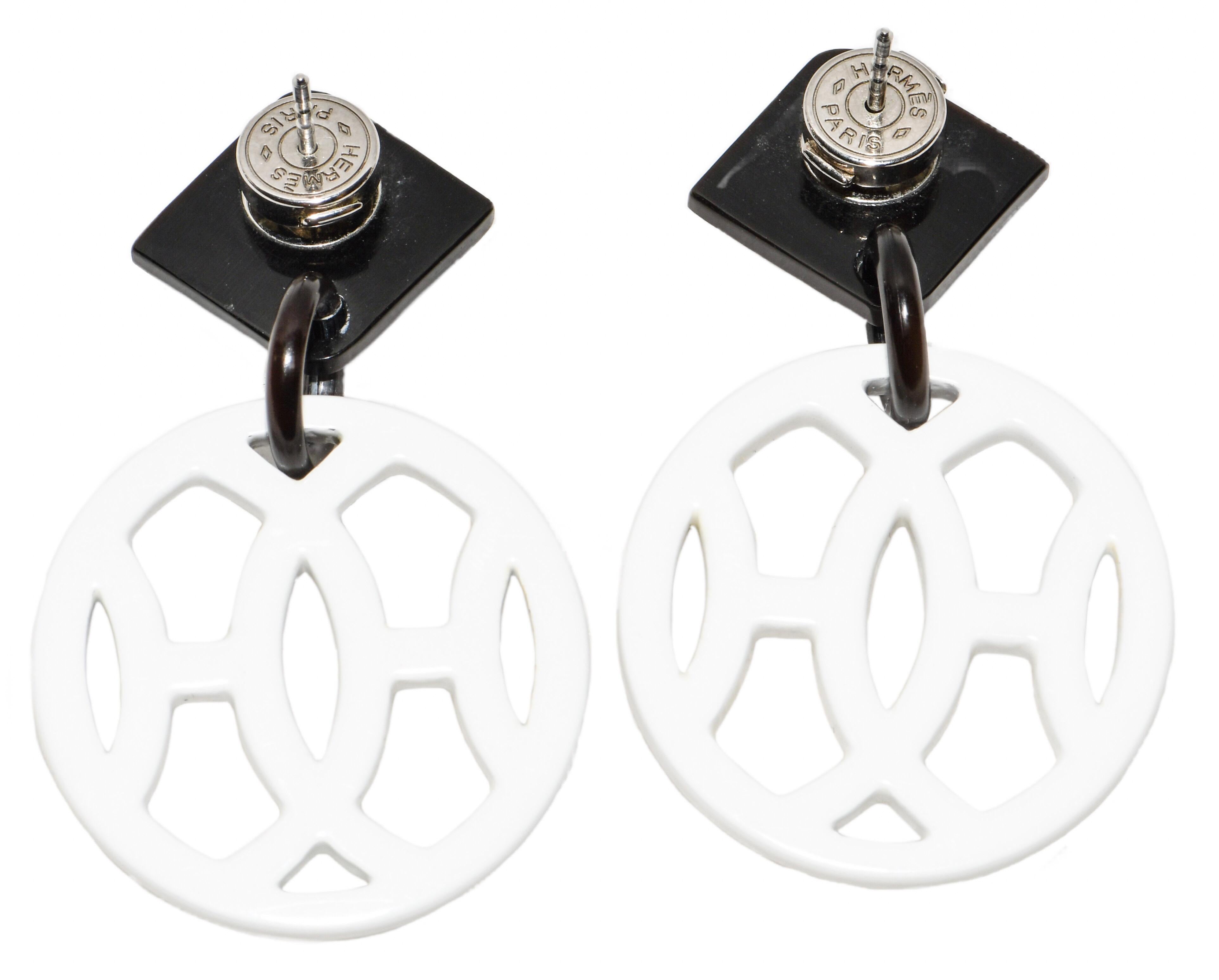 Hermes is known the world over.  Their products are highly collectible and instantly recognizable! These fabulous dangle earrings feature a lacquered wood top with a dangling circle featuring intertwined H's fabricated from buffalo horn.  Hardware