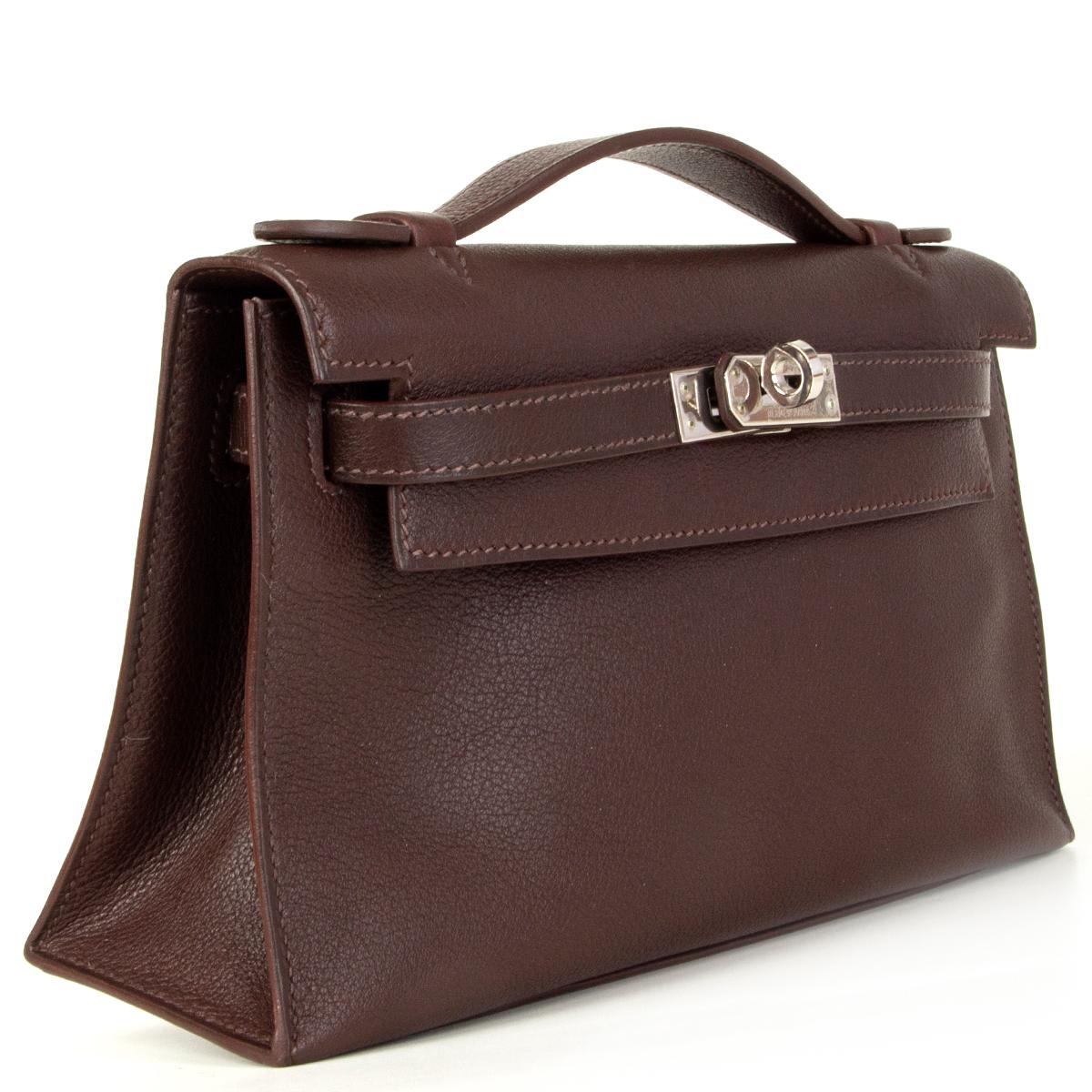 Hermès 'Kelly Pochett' clutch in Havane (chestnut brown) Vea Swift leather with palladium hardware. Lines in Chevre (goat skin) with an open pocket against the back. Brand new comes with dust bag. 

Height 14cm (5.5in)
Width 22cm (8.6in)
Depth 7cm