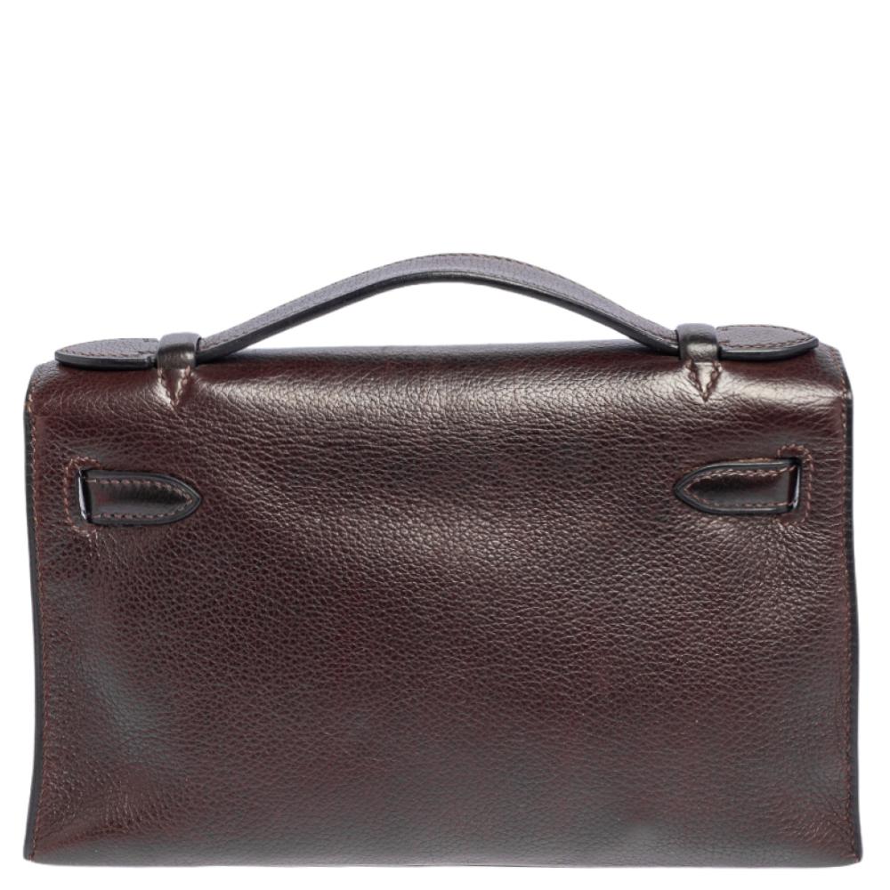 This Kelly Pochette is a delighting find. Named and inspired by the world-famous Kelly bag, this wondrous work of art is presented in Evergrain leather and secured by the iconic Kelly lock. Its flap opens to reveal a well-sized leather interior and