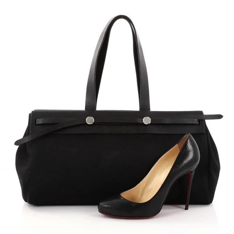 This authentic Hermes Herbag Cabas Toile and Leather GM is a fabulously functional lightweight tote made for everyday excursions. Constructed from black toile and vache hunter leather, this versatile tote features a flat leather top handle, hidden