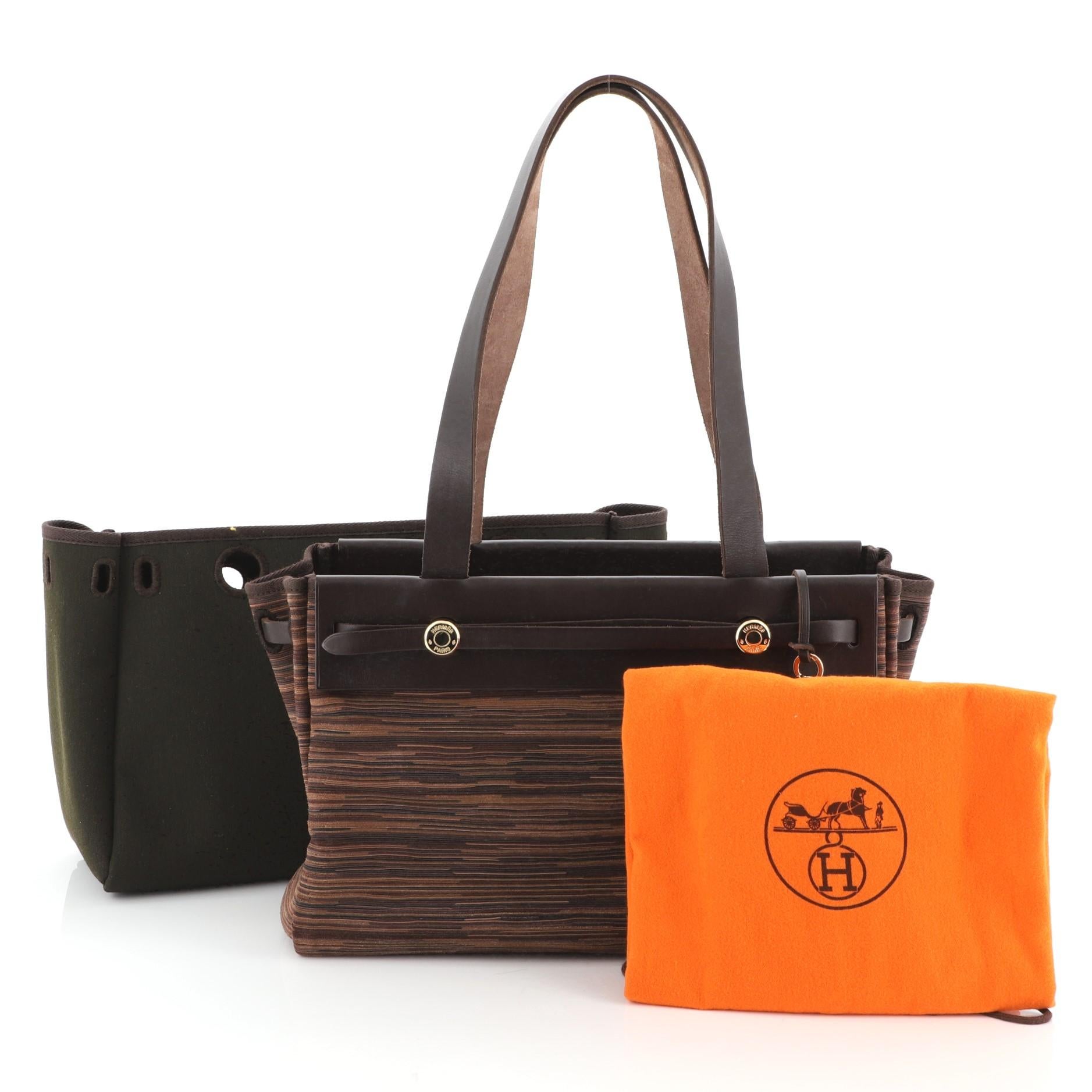 This Hermes Herbag Cabas Vibrato and Leather PM, crafted from Ebene brown Vache Hunter and multicolor Vibrato, features flat leather handles and gold hardware. It opens to a Rouge H and multicolor Vibrato interior. Date stamp reads: H Square (2004).