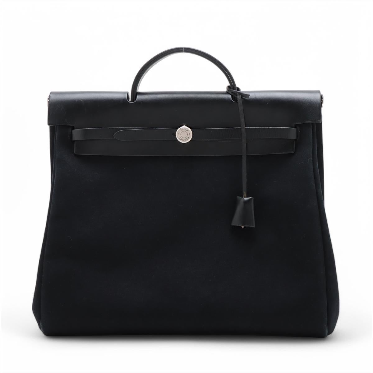 The Hermès Herbag MM in Black is a refined yet practical handbag that seamlessly blends timeless elegance with everyday functionality. Often dubbed the “two-in-one” bag, it features a removable canvas body and a structured Vache Hunter leather top