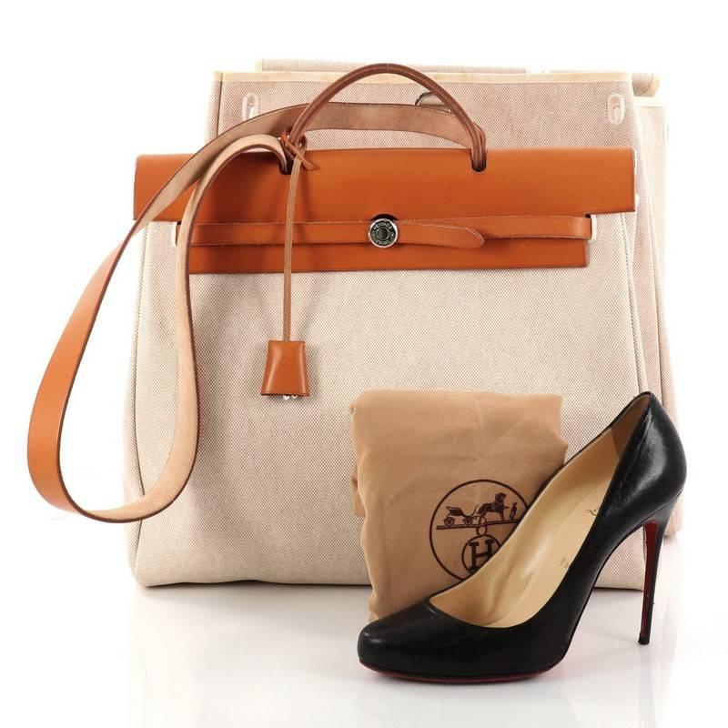This authentic Hermes Herbag Toile and Leather MM is a fabulously functional Hermes set with two stylishly classic handbags fitting any mood. Constructed from beige natural toile and natural vache hunter leather, this functional interchangeable bag