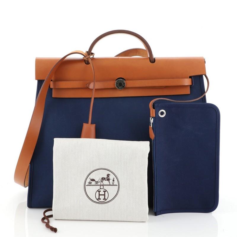 This Hermes Herbag Zip Leather and Toile 39, crafted from Natural Vache Hunter and Bleu de Malte blue Toile Officier, features an external zip pocket, single looped handle, and palladium hardware The frontal rod opens to a Bleu de Malte blue Toile