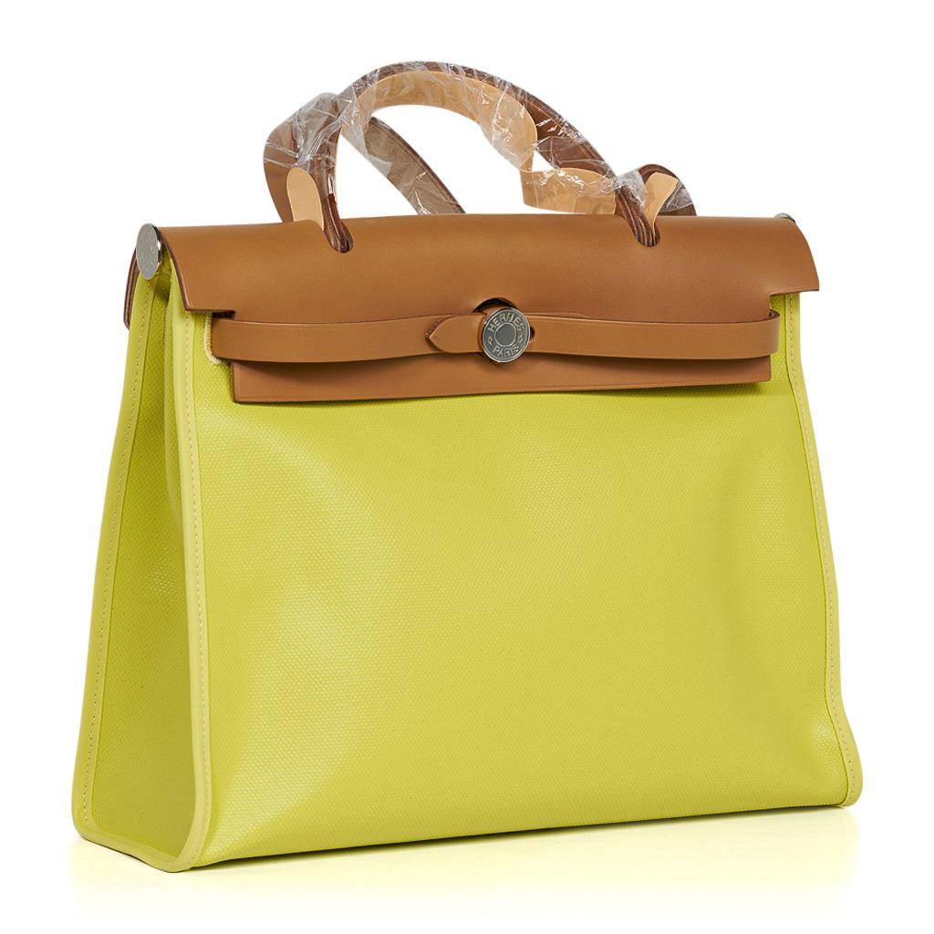Hermes Herbag Zip 31 featured in Lime Berline Toile, a coated canvas, and Natural Sable Vache Hunter leather.
Rear has an exterior Ecru and Beige toile canvas zip pocket.
Interior is matching toile to the exterior pocket and has a matching removable