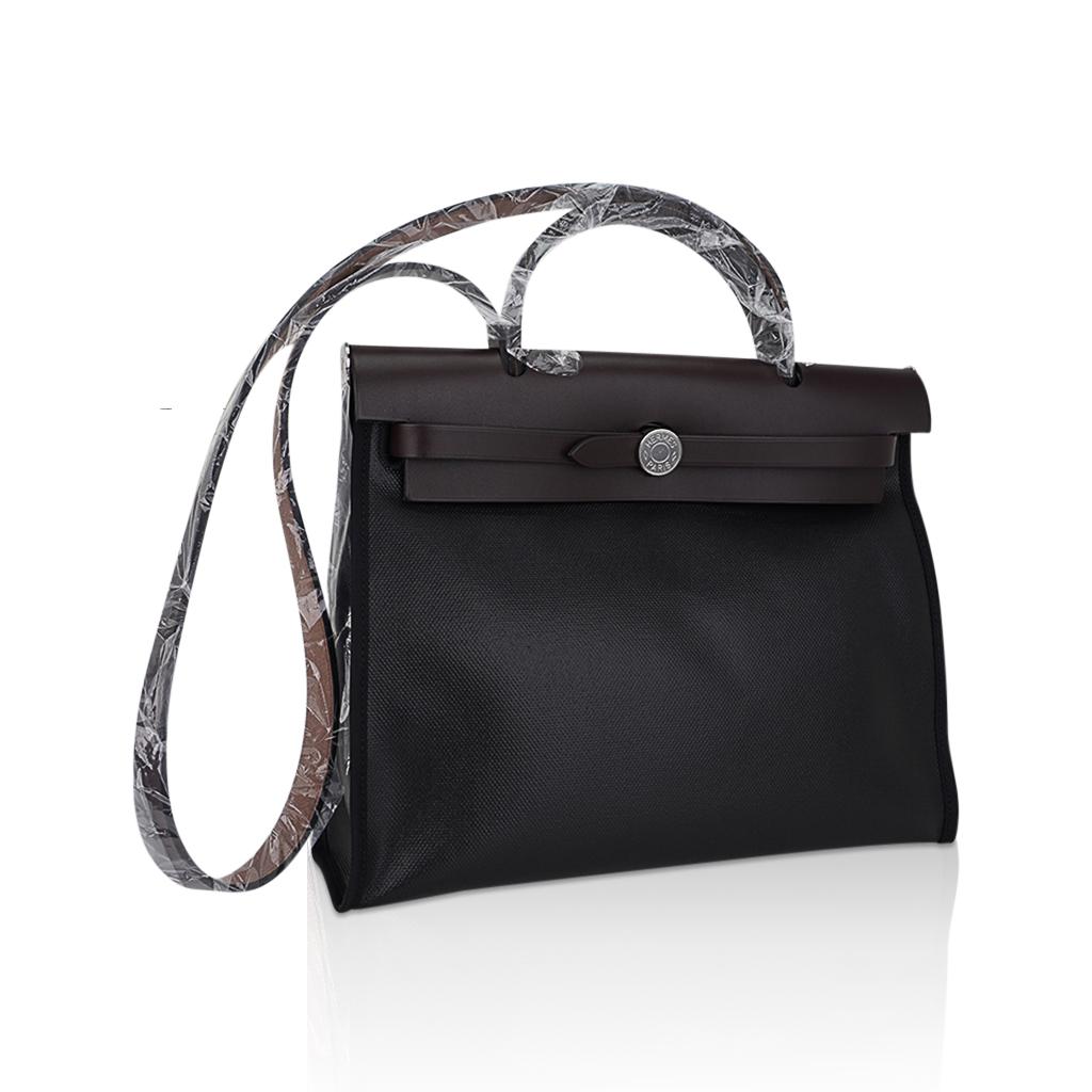 Mightychic offers an Hermes Herbag Zip 31 featured in Black Berline canvas and Rouge Sellier leather.
The water resistant coated canvas makes this fabulous Hermes Herbag a great travel bag too.
Signature Herbag Clou de Selle in Palladium