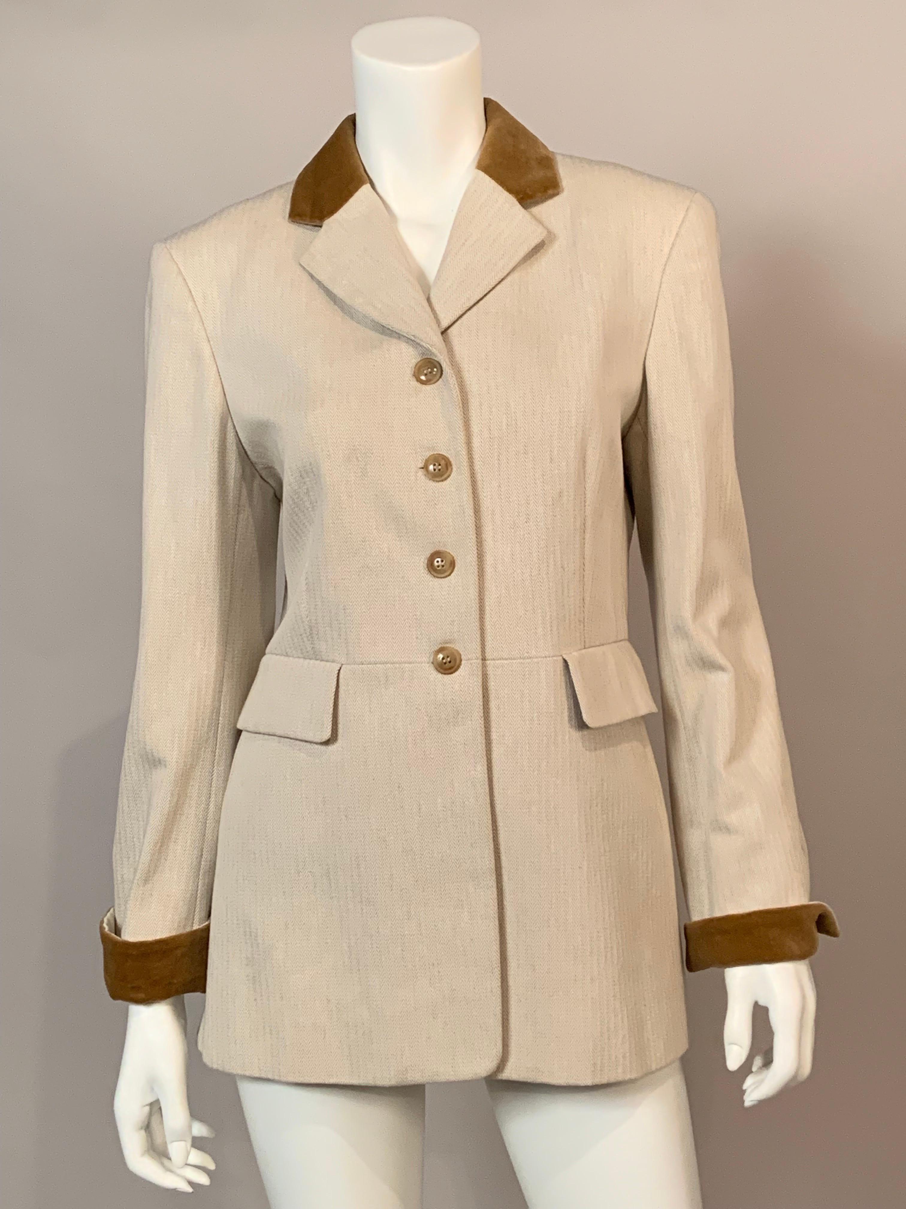 This Hermes jacket is designed in the classic equestrian riding jacket style.  The cream cotton herringbone is accented by a velvet collar, notched lapels, four button closure, two pockets and three button velvet cuffs. At the back there are two