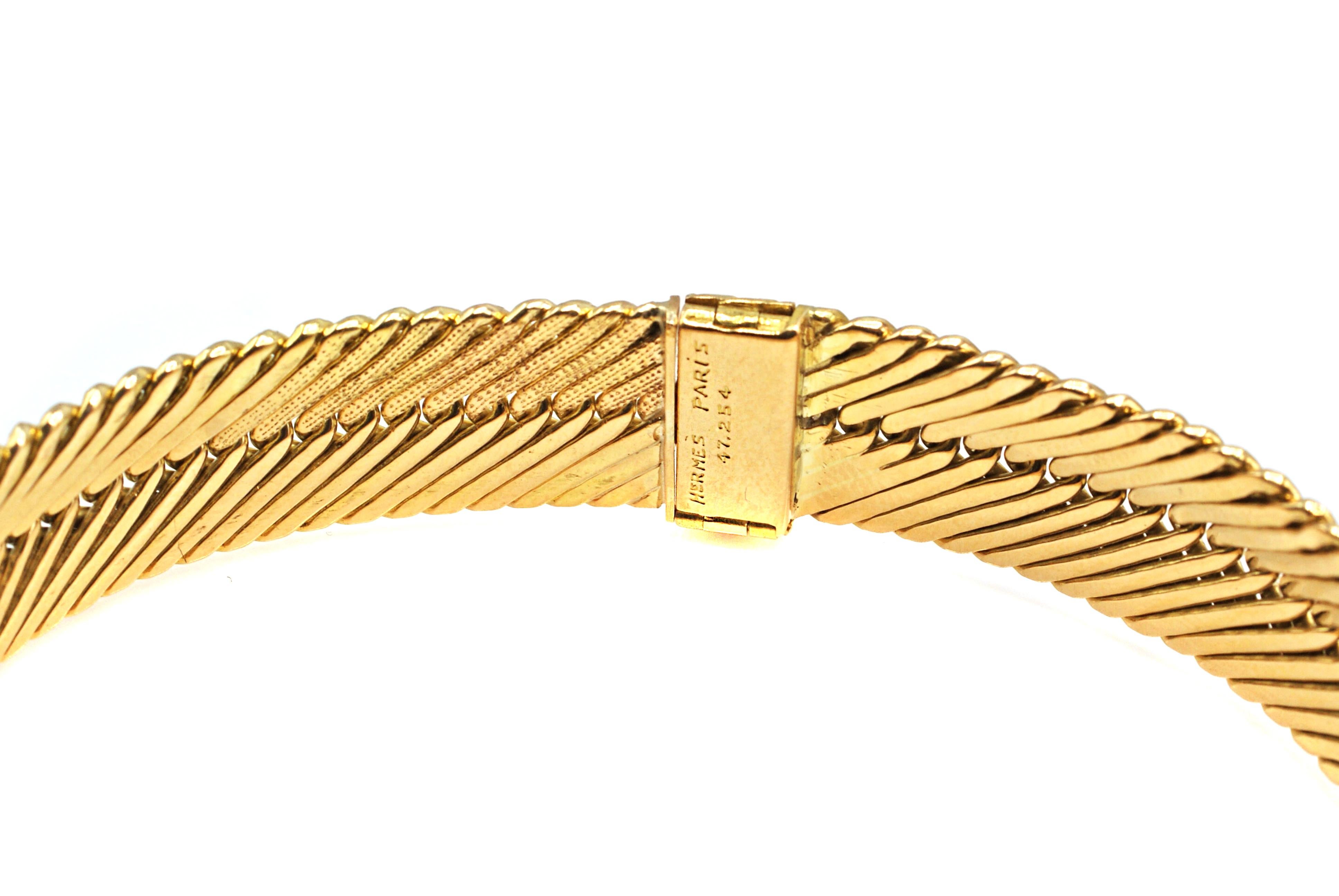 Beautifully hand-crafted this chic and stylish 18 karat yellow gold bracelet by Hermes Paris is a must-have accessory. The flexible links in a herringbone design have half the side in a high polished gold while the other half displays granulated