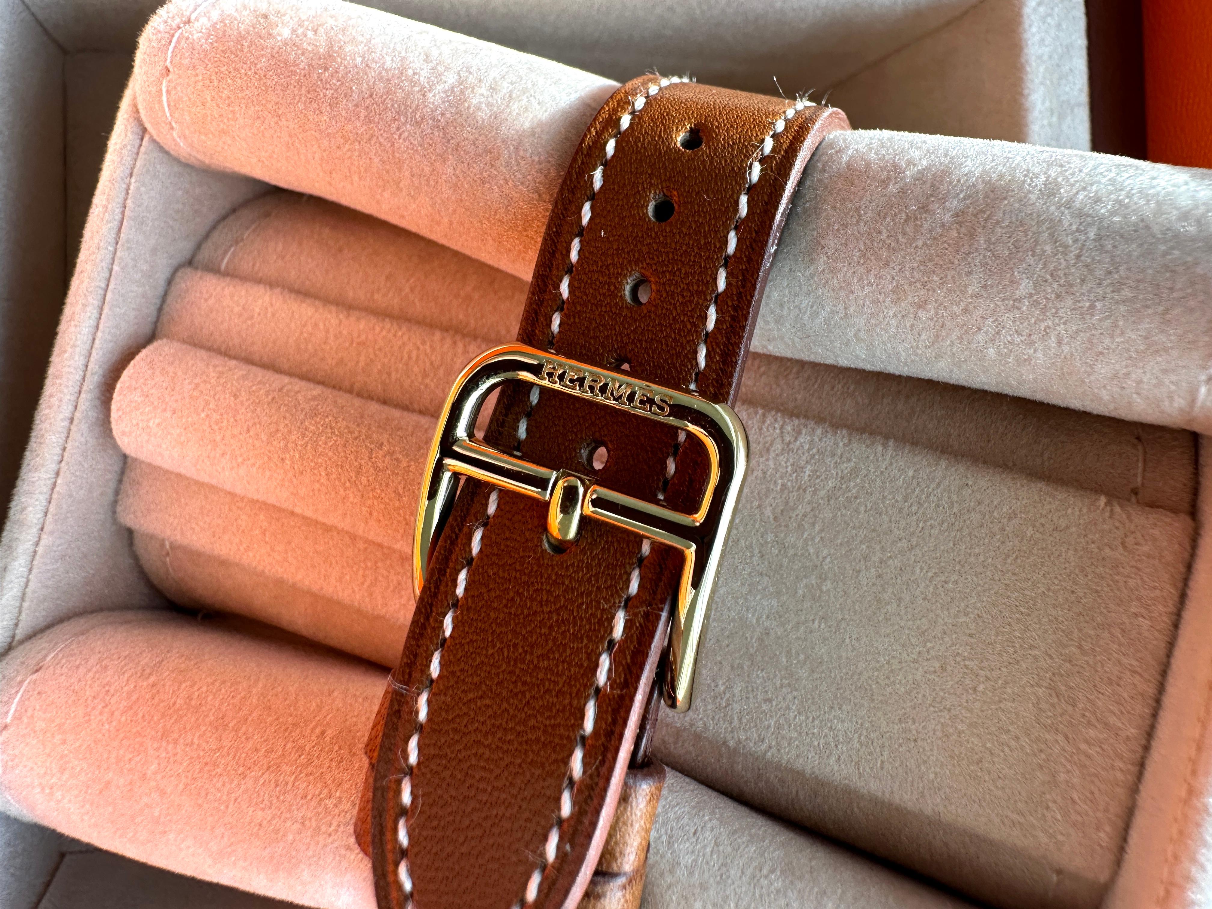 Hermes Heure H 25mm Uhr
Barenia

Uhr aus gelbvergoldetem Stahl, Quarzwerk, weißes Zifferblatt, langes, austauschbares Armband aus natürlichem Barenia-Kalbsleder

Die Uhr wird in der Schweiz hergestellt
Das Armband wird in Frankreich