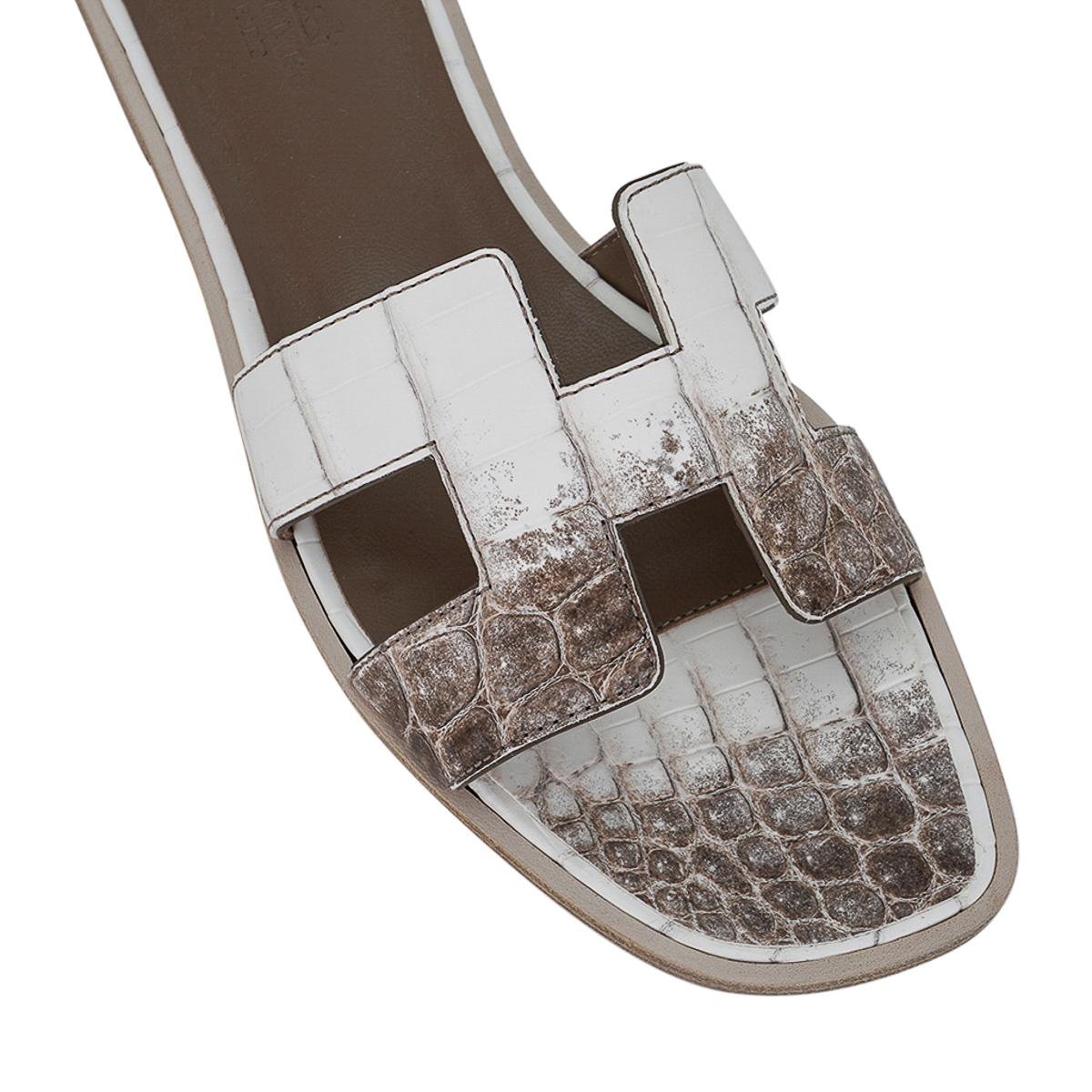 Mightychic offers Hermes  Himalaya matte alligator Oran sandals.
These stunning limited edition Hermes Oran flat slide sandals are a rare find.
The iconic H cutout over the top of the foot.
Wood heel with leather sole.
Comes with sleepers, signature