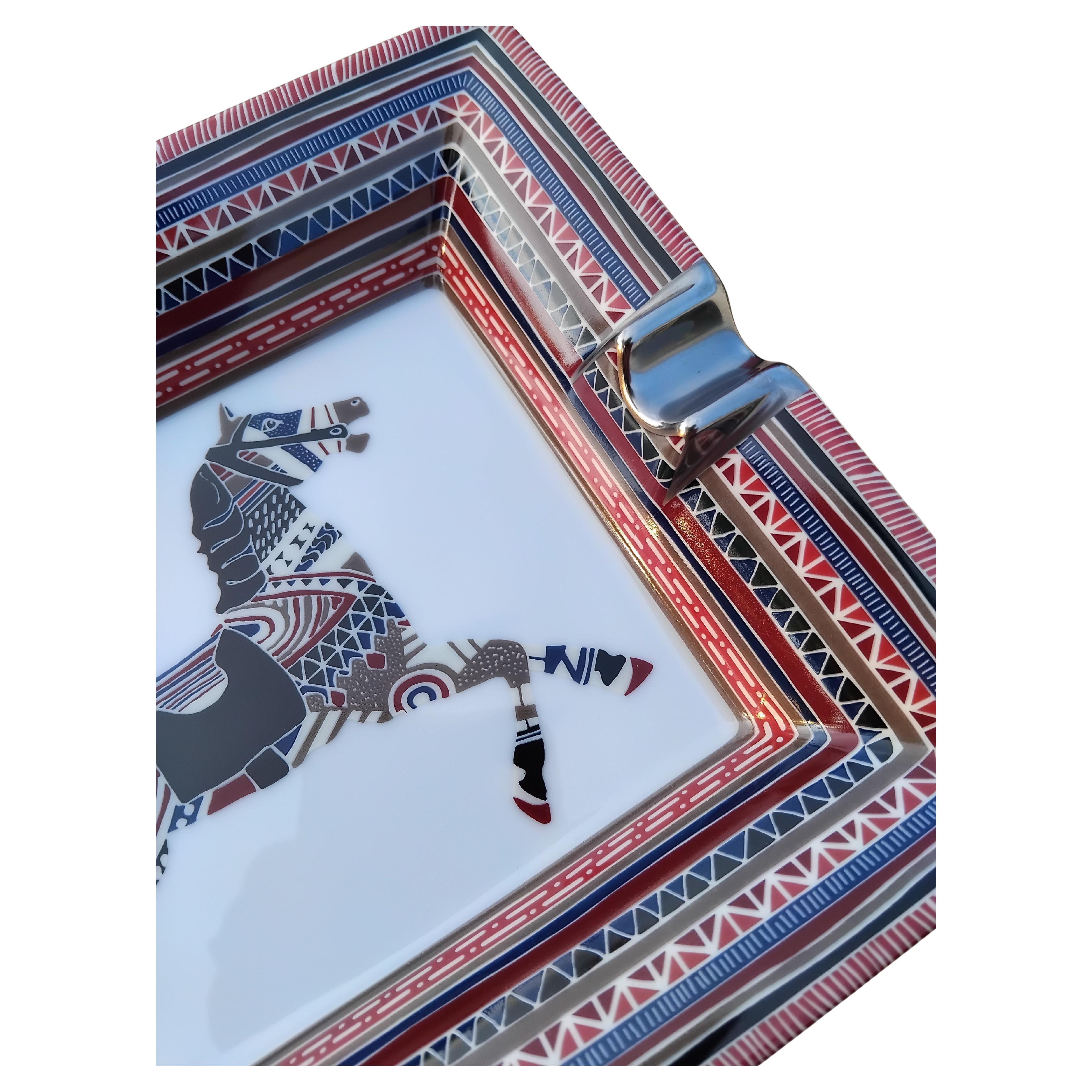 Extremadamente Raro y Precioso Cenicero Hermès Auténtico

Imprime: Caballo

Tema: equitación, rodeo

Fabricado en Francia

De porcelana impresa, muescas recubiertas de platino (tono plateado)

Parte inferior forrada de piel de ante rojo oscuro,