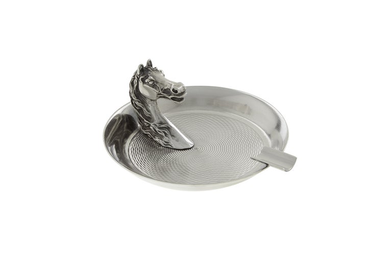 A fine and elegant ashtray by Hermes. Featuring an engine-turned texture and a rest for your smoke.

 