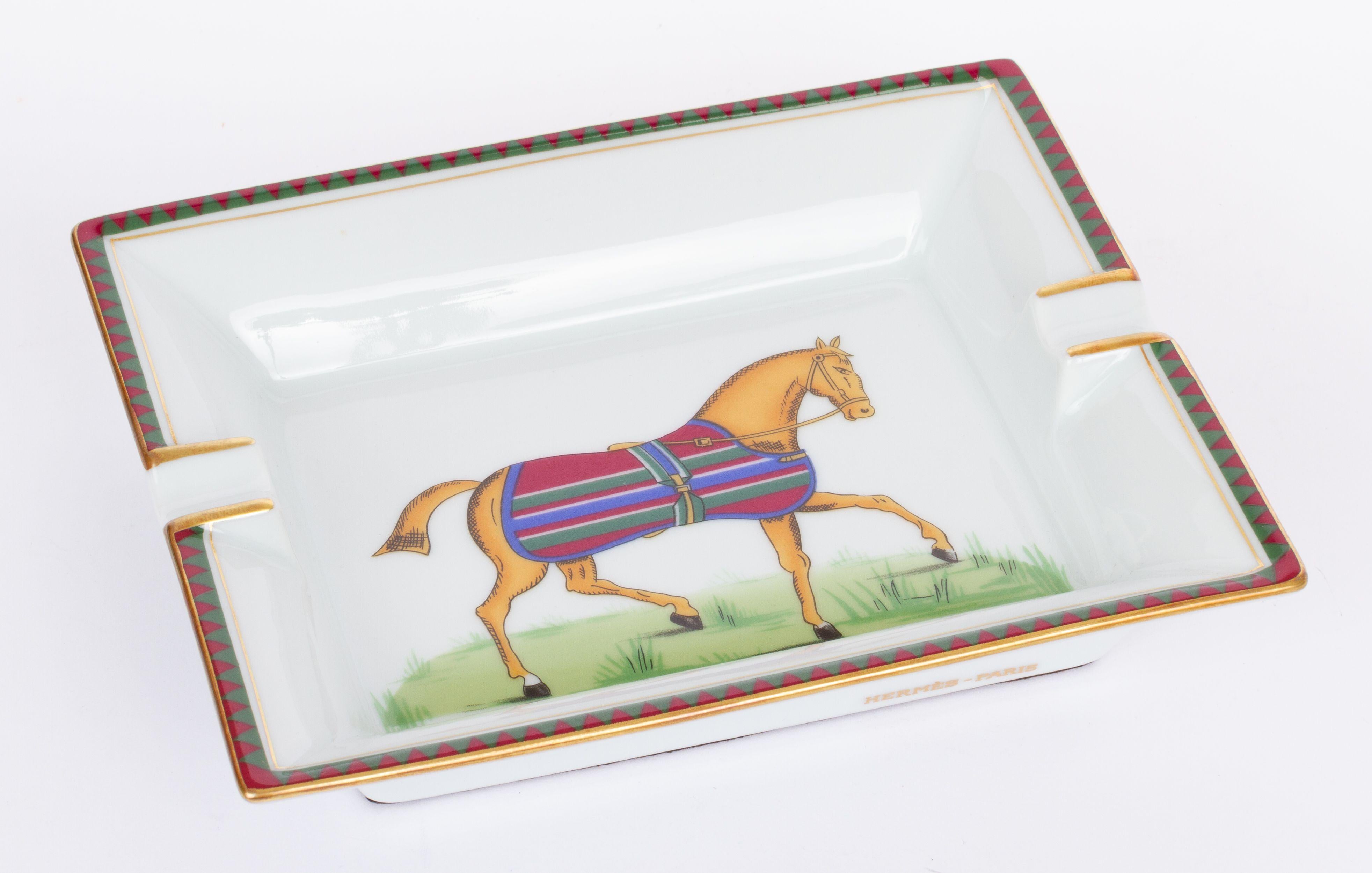 Hermès vintage ashtray in white with a horse in the center. The horse is decorated with a striped blanket. The piece is in excellent condition.